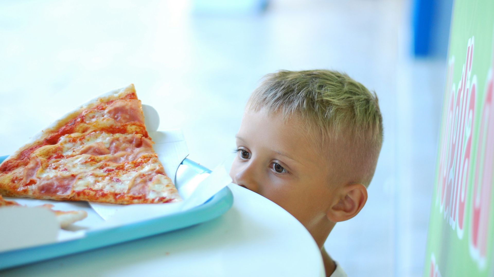 baby in white shirt eating pizza
