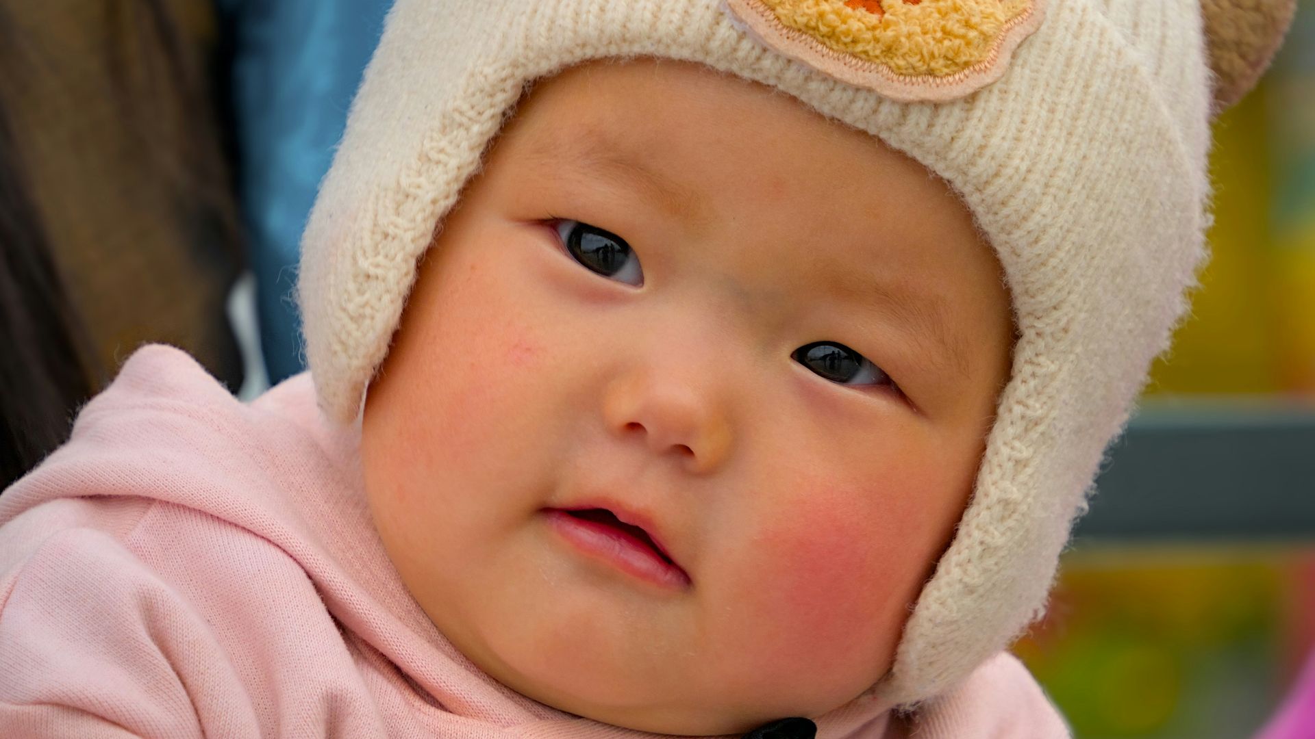 A cute baby wearing a bear hat.