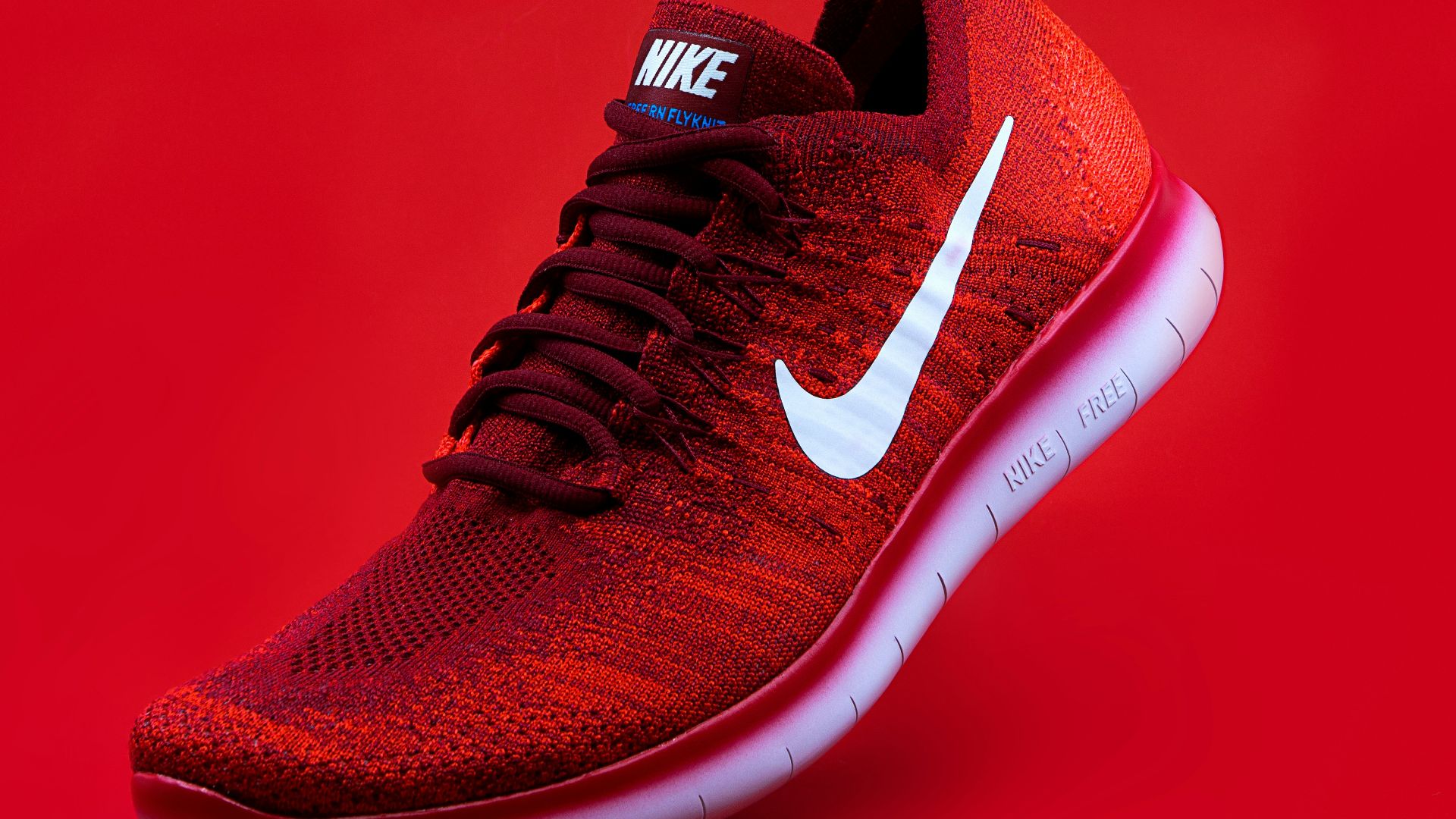 unpaired red Nike sneaker