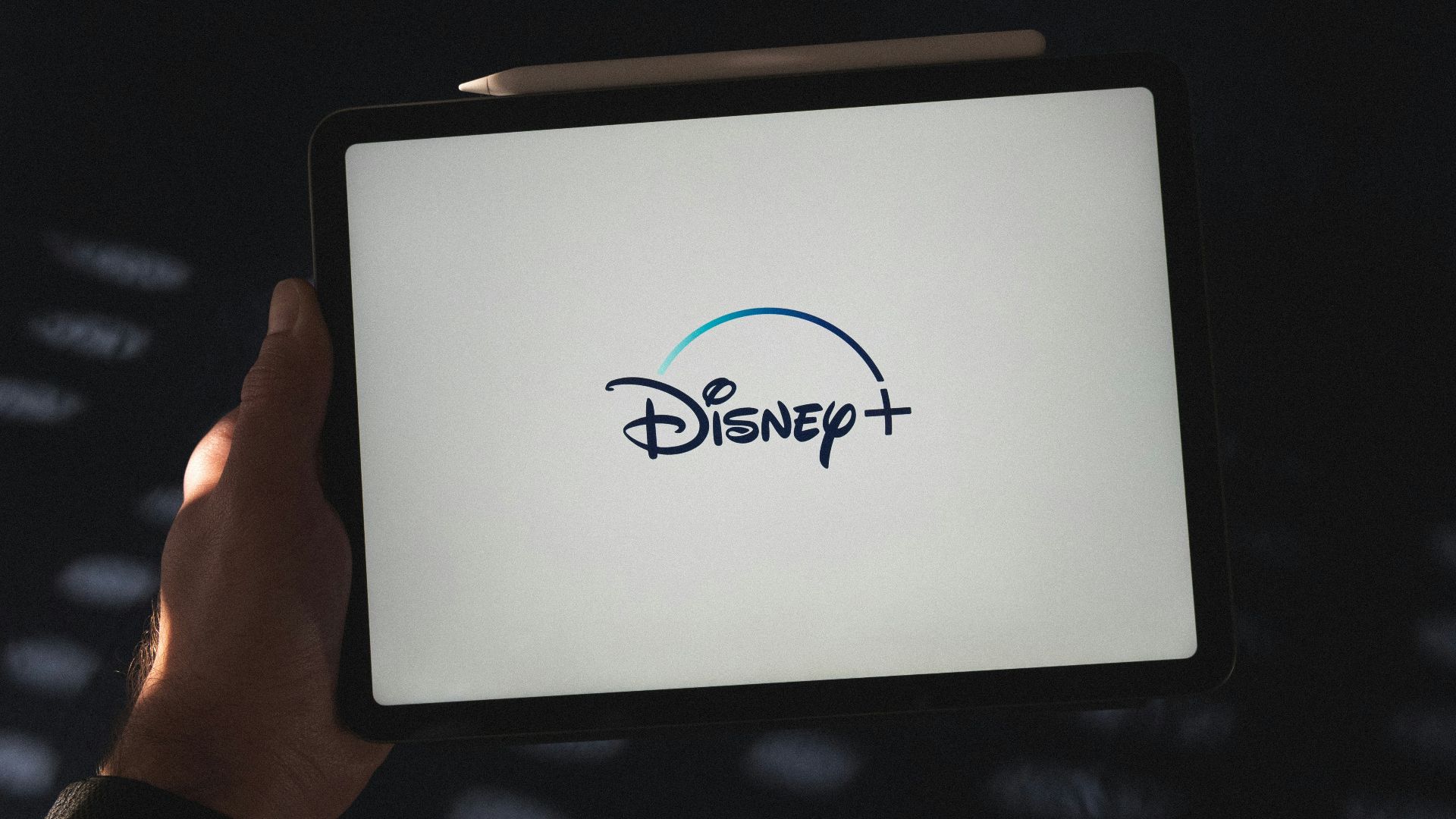 a person holding a tablet with a disney logo on it