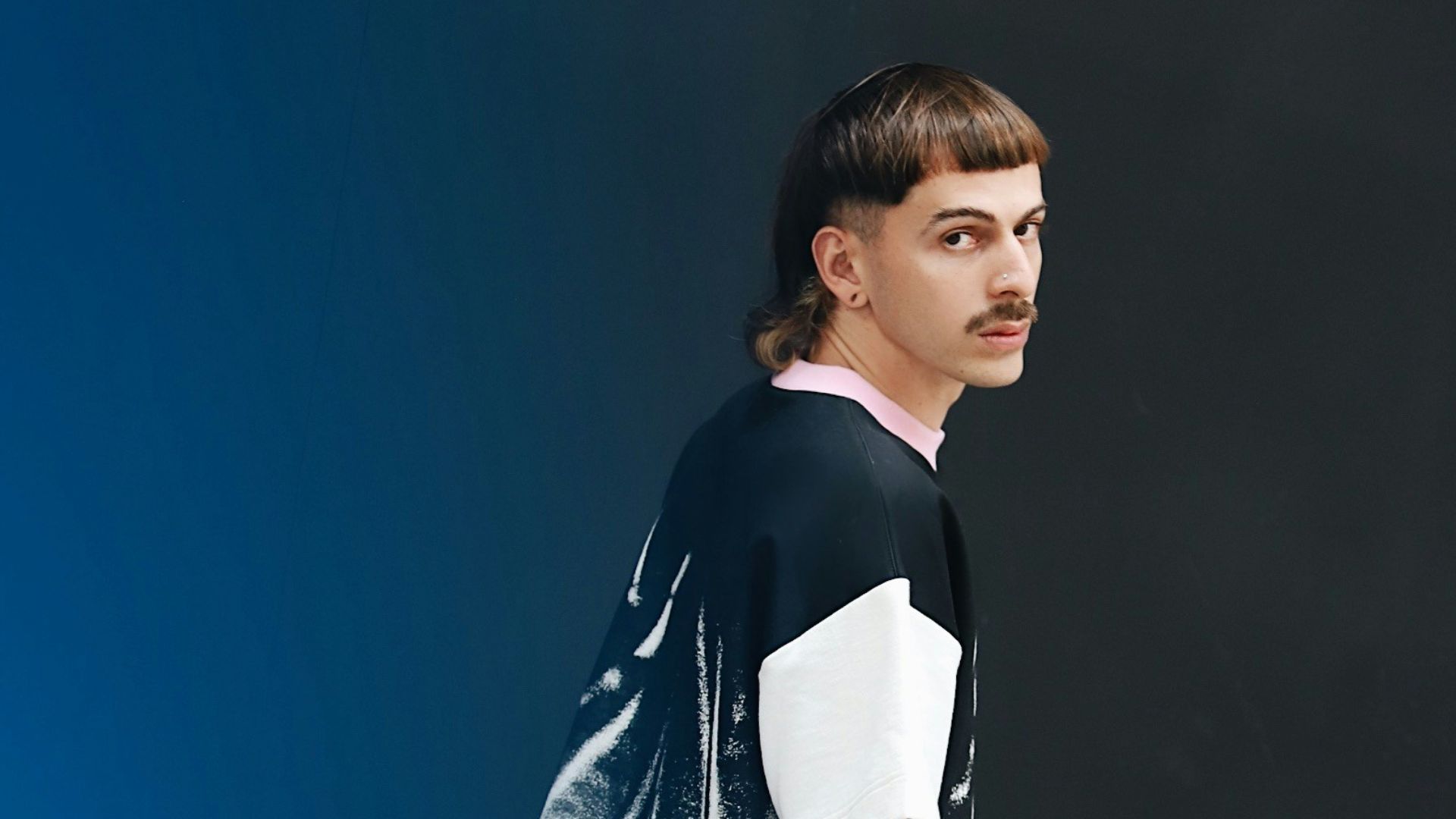 a man standing in front of a blue wall