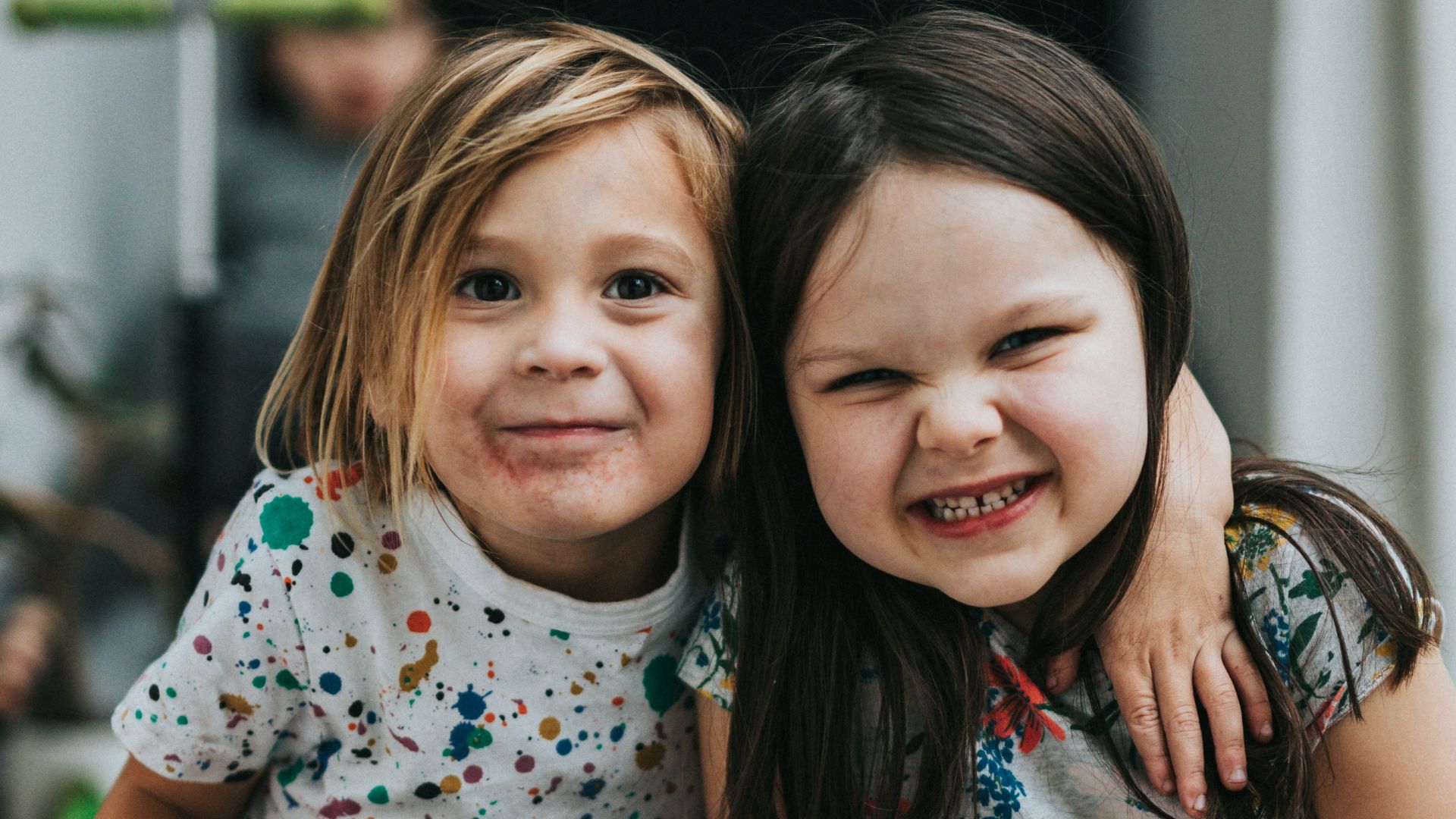 2 girls sitting on concrete floor
