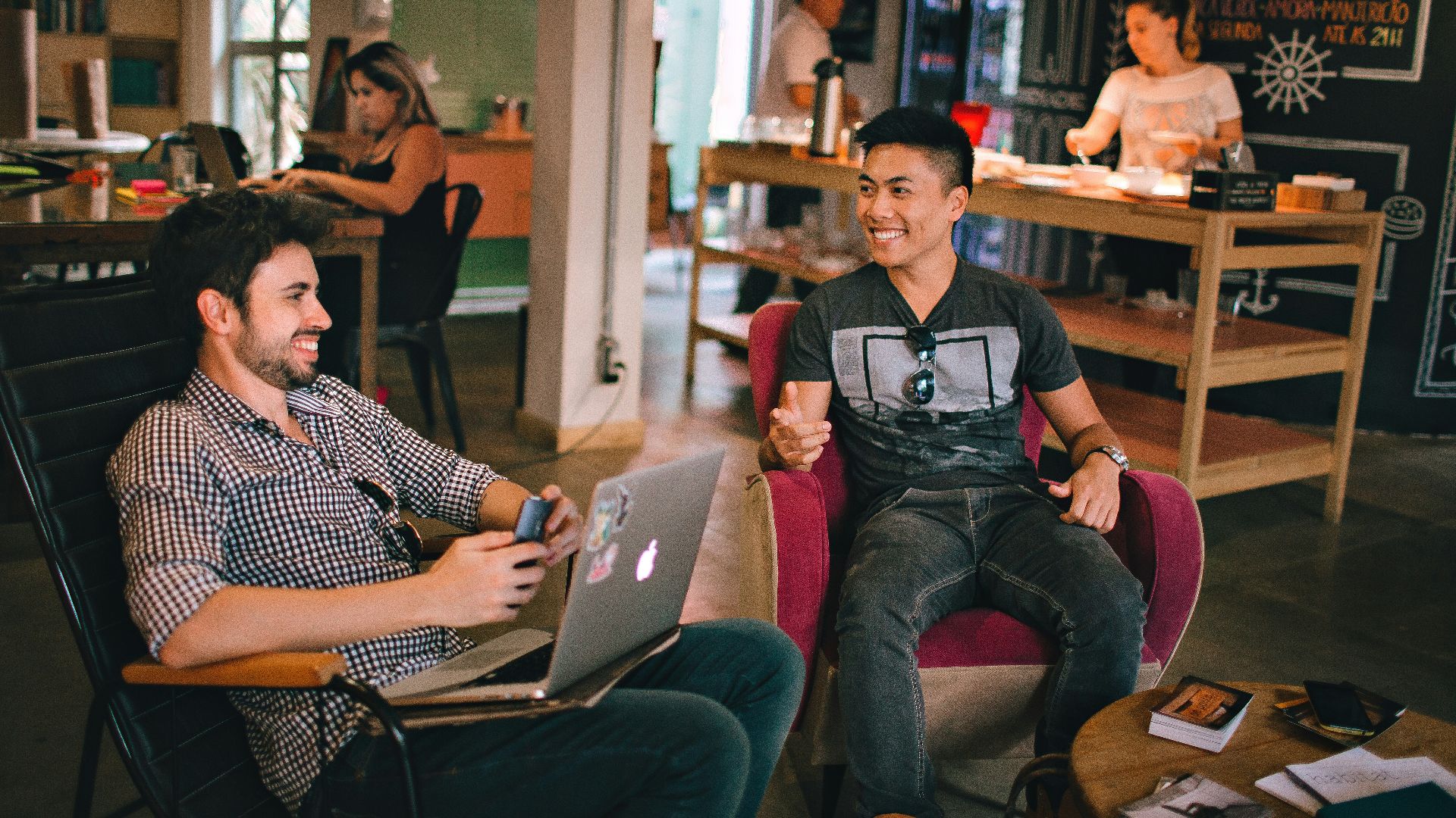 two men laughing white sitting on chairs