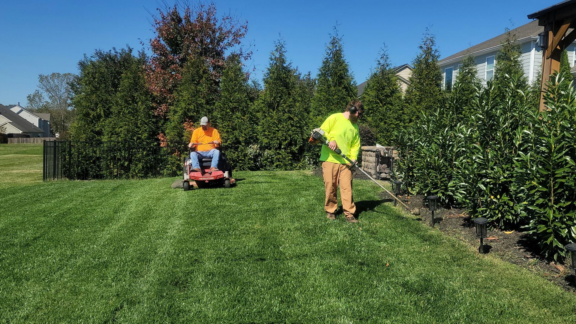 A man mowing a lawn with a lawn mower