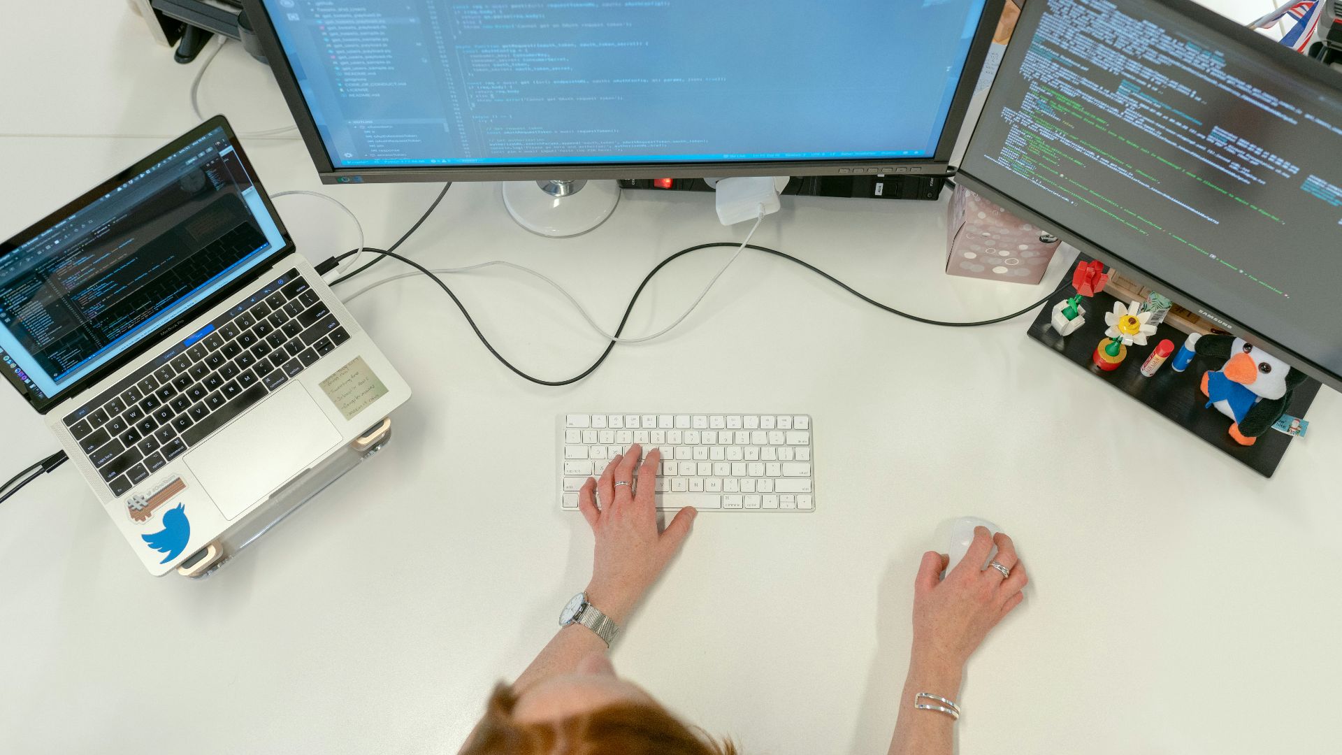 person using macbook pro on white table