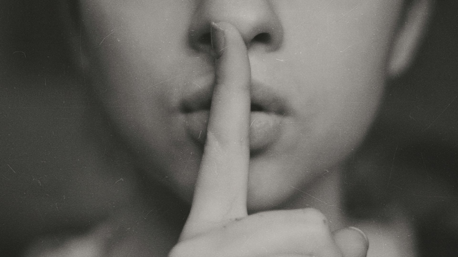 grayscale photo of woman doing silent hand sign