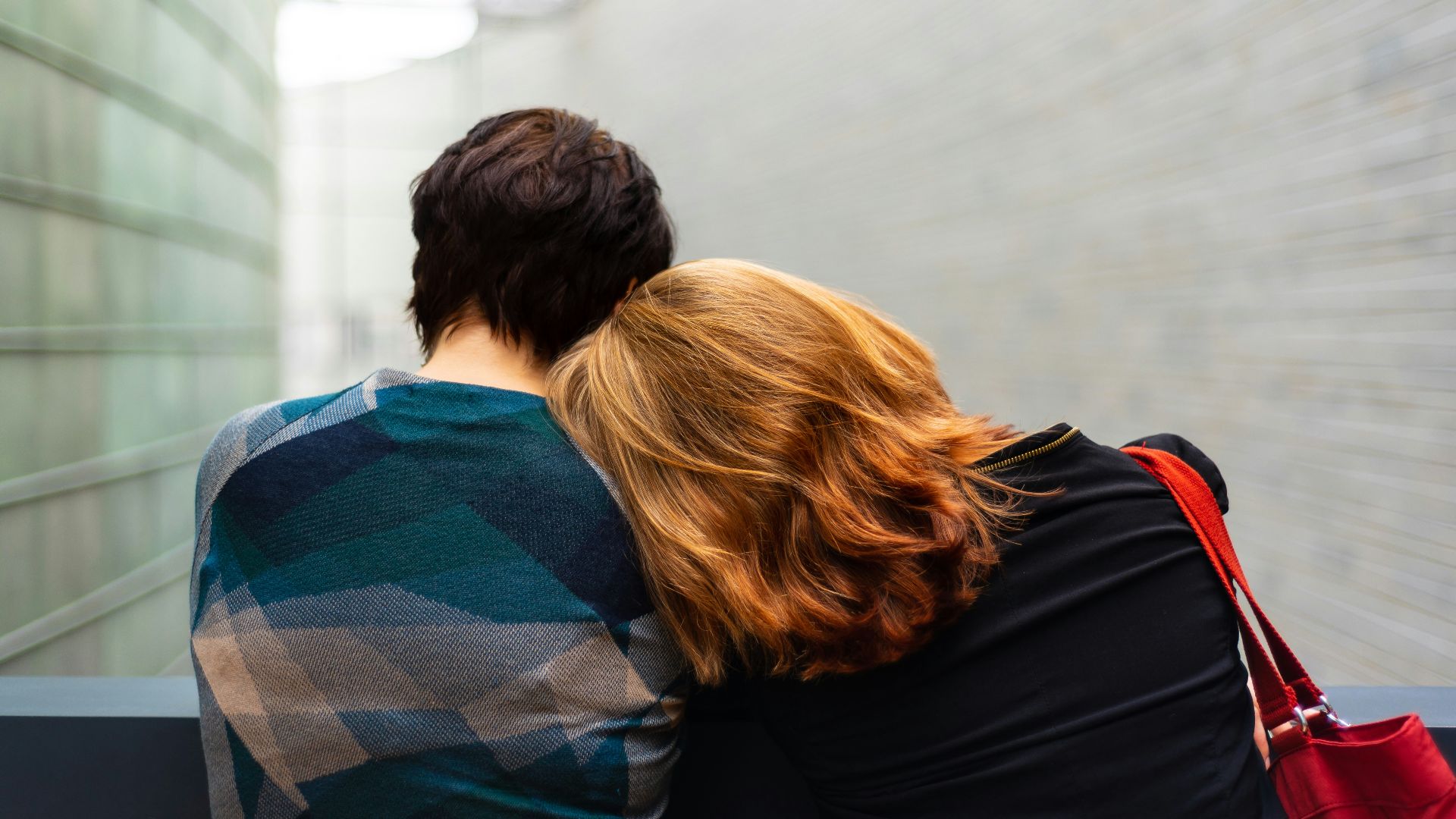 a woman rests her head on another person's shoulder