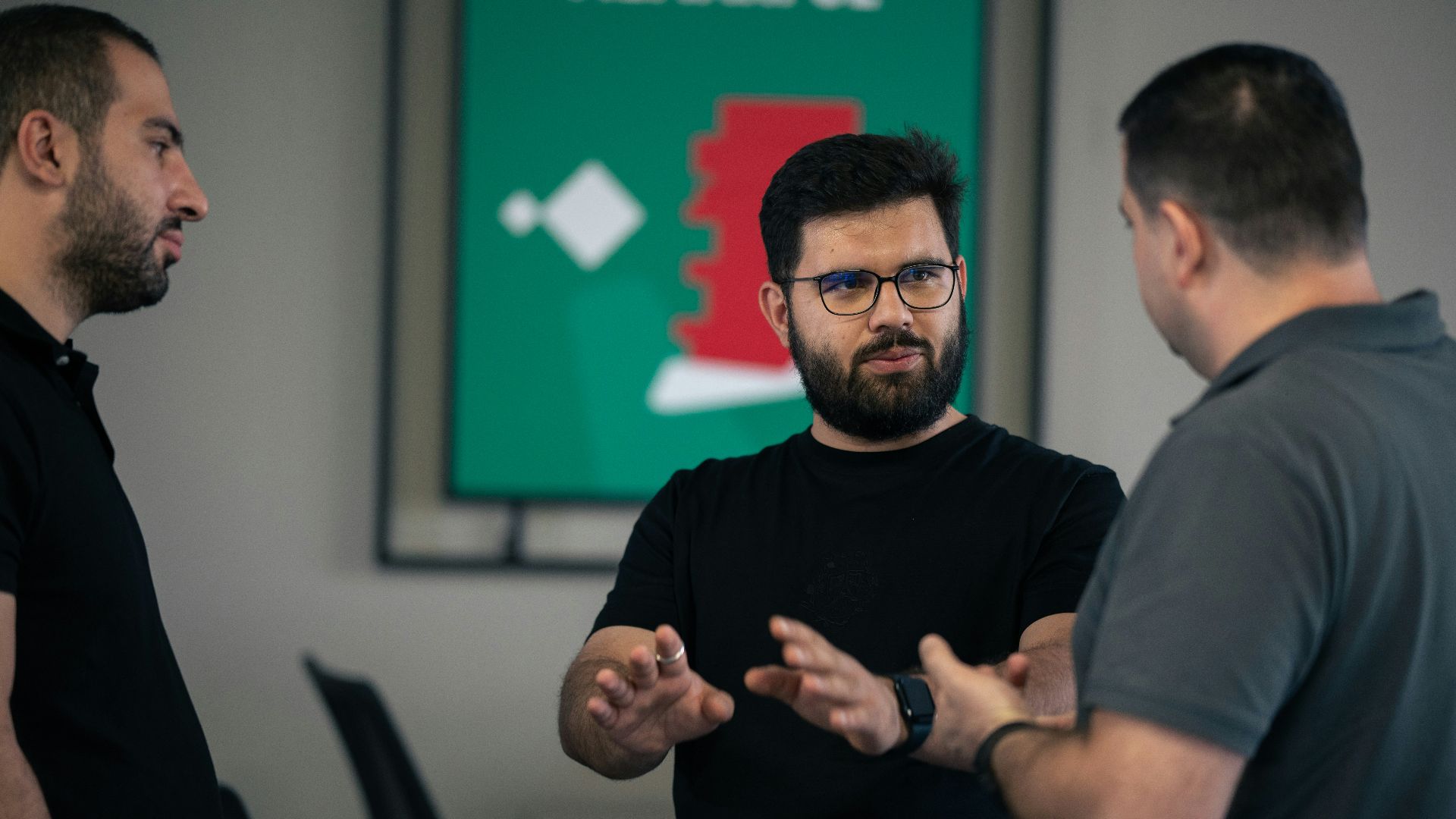 A group of men standing around each other in a room
