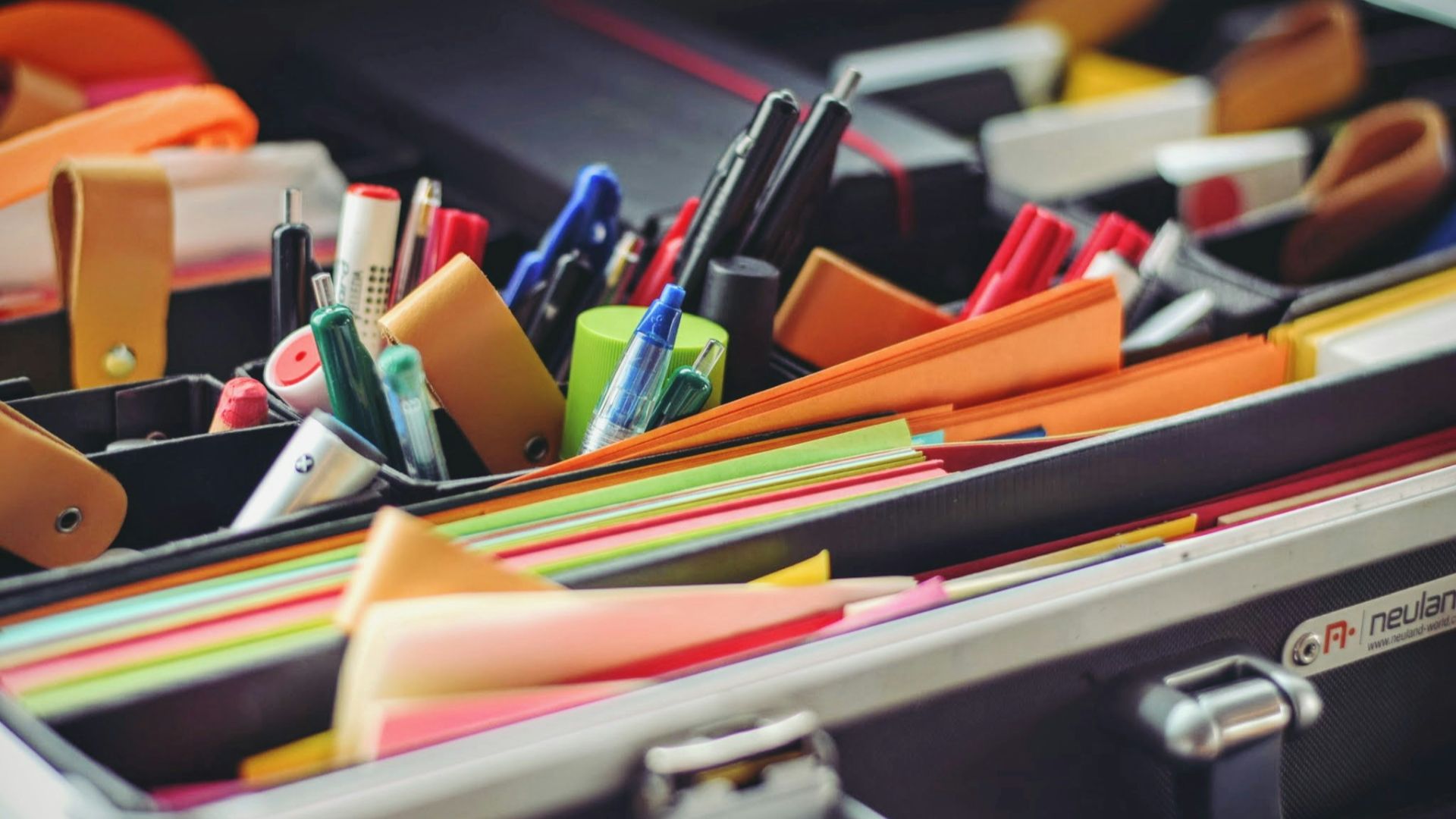 assorted pen and colored papers in organizer case