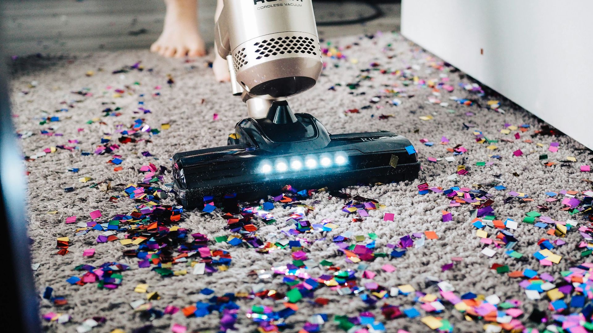 a person using a vacuum to clean a carpet
