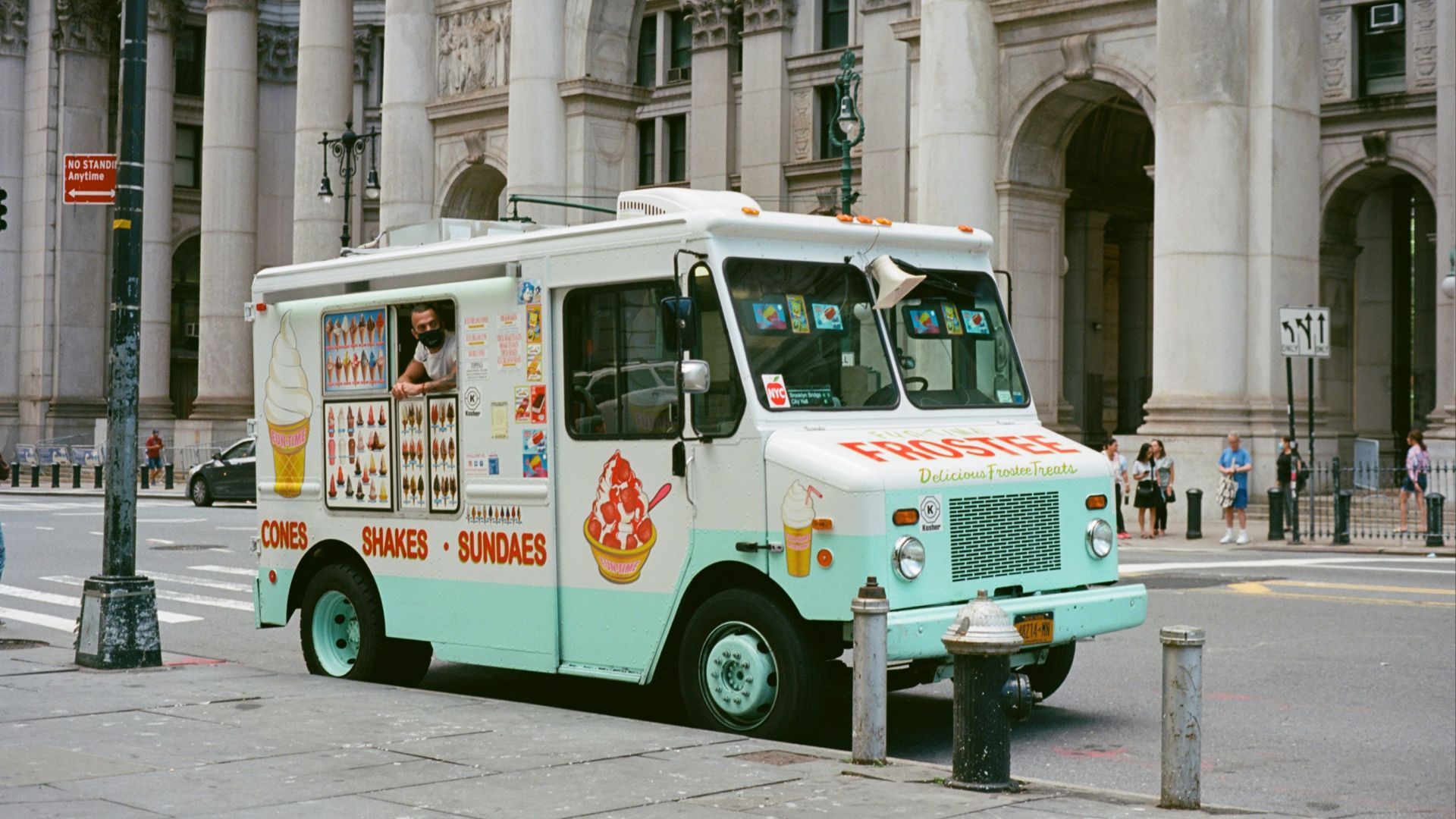 white and green van parked beside building during daytime