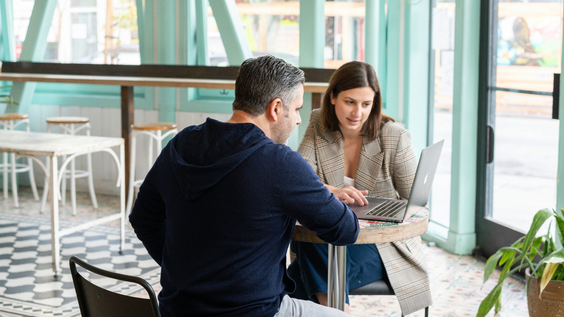 man in black long sleeve shirt sitting on chair beside woman in black and white stripe