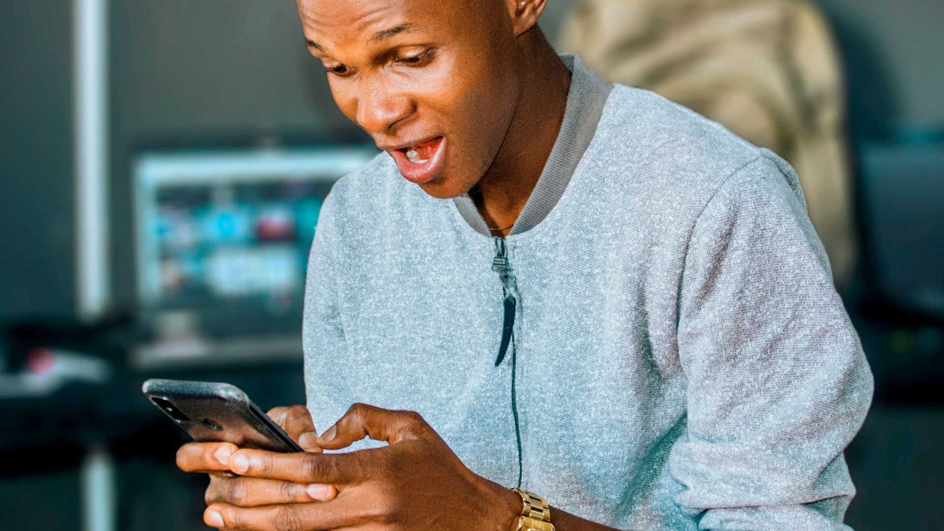 a man looking at his cell phone and laughing