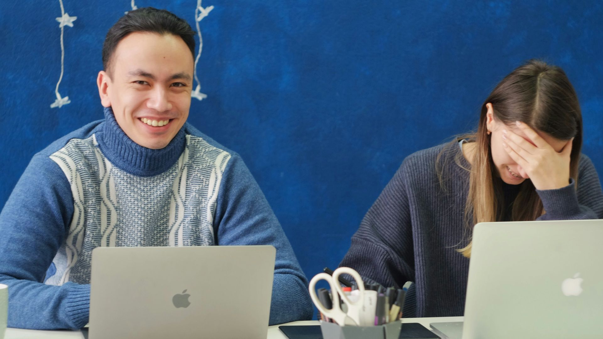 woman in gray sweater using silver macbook