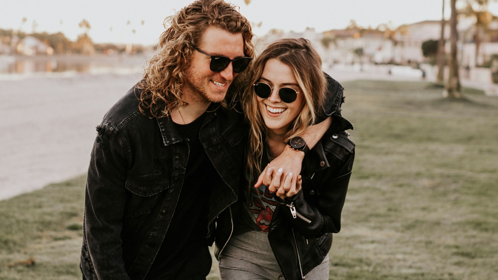 woman in black leather jacket and gray pants standing on green grass field during daytime