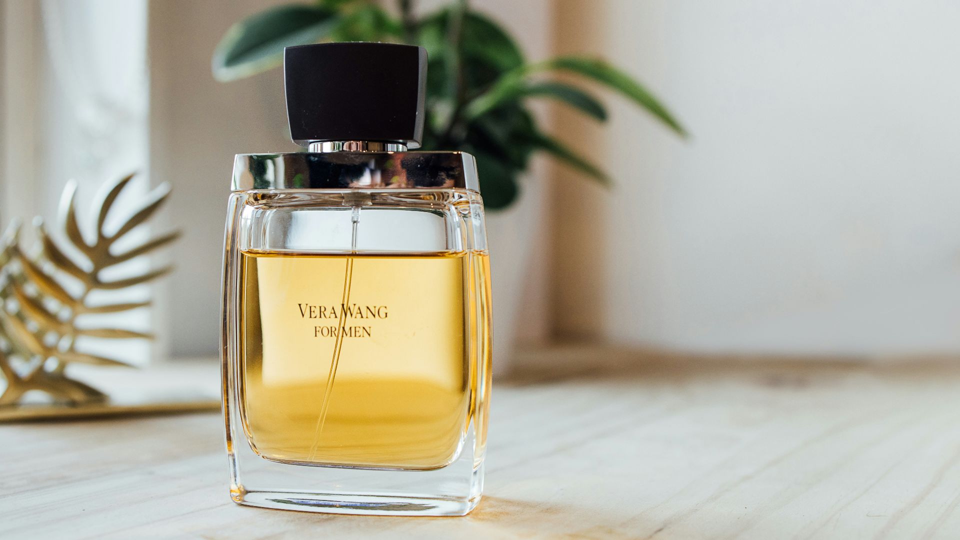 clear glass perfume bottle on brown wooden table