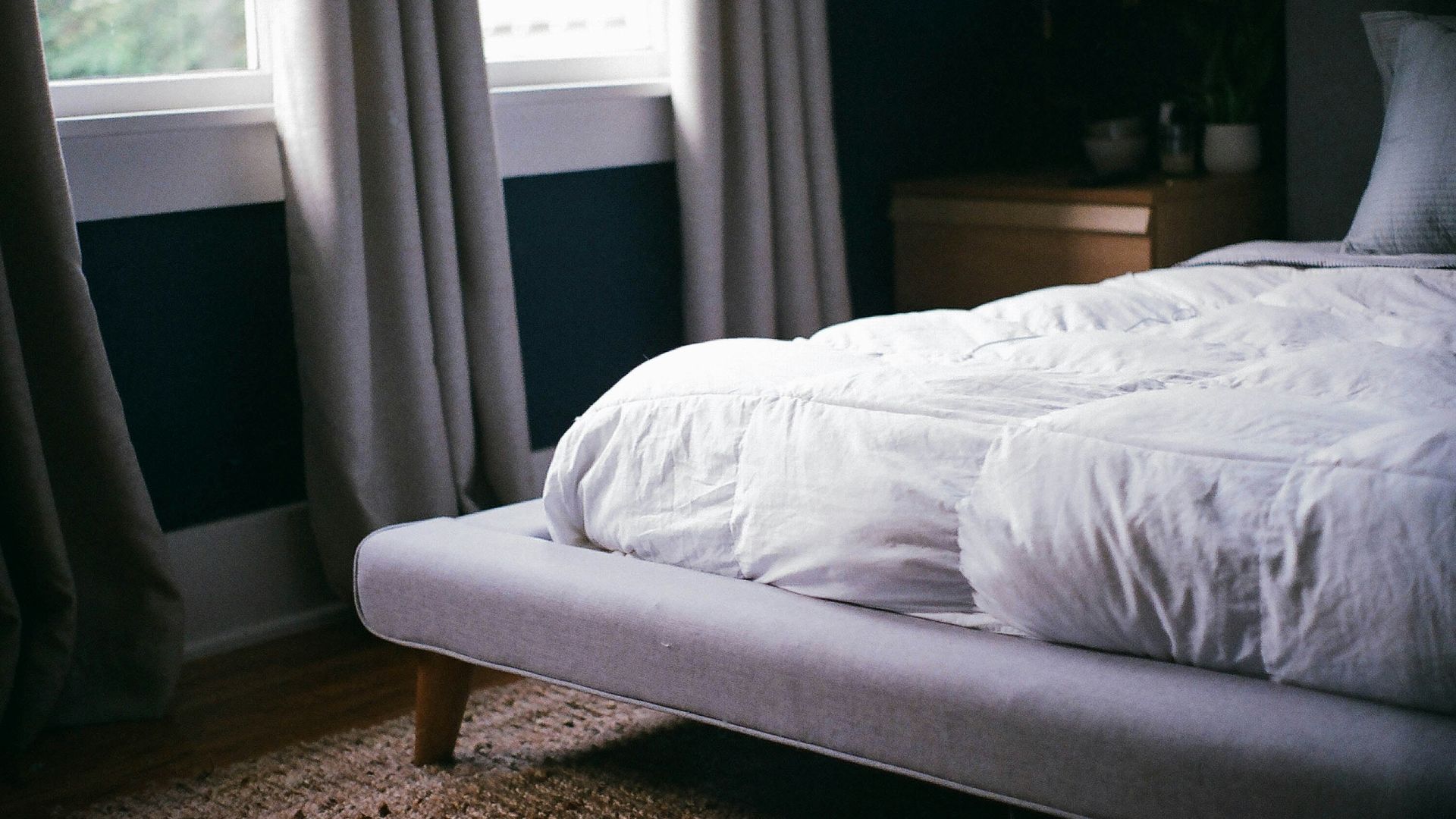 white bed by the window during daytime