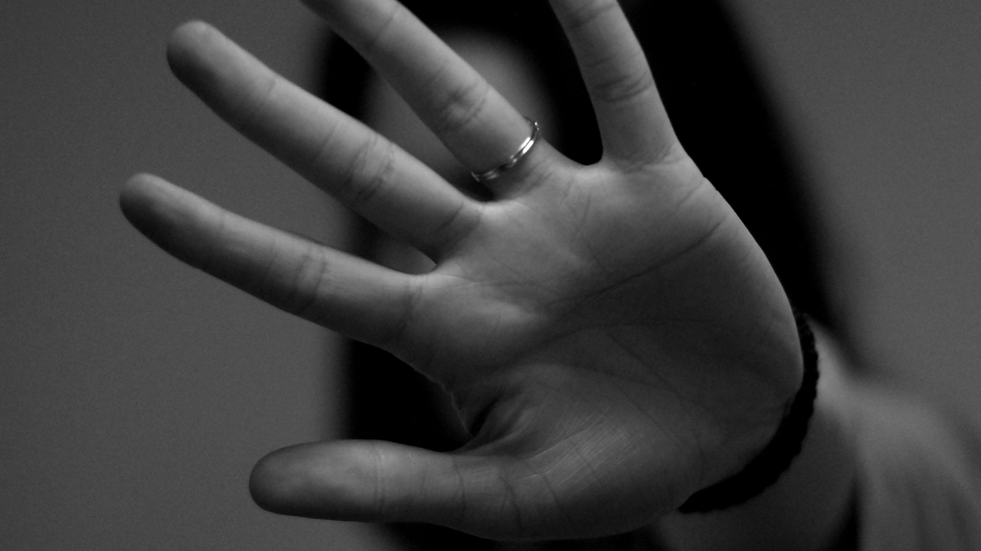 woman showing left hand with wedding band
