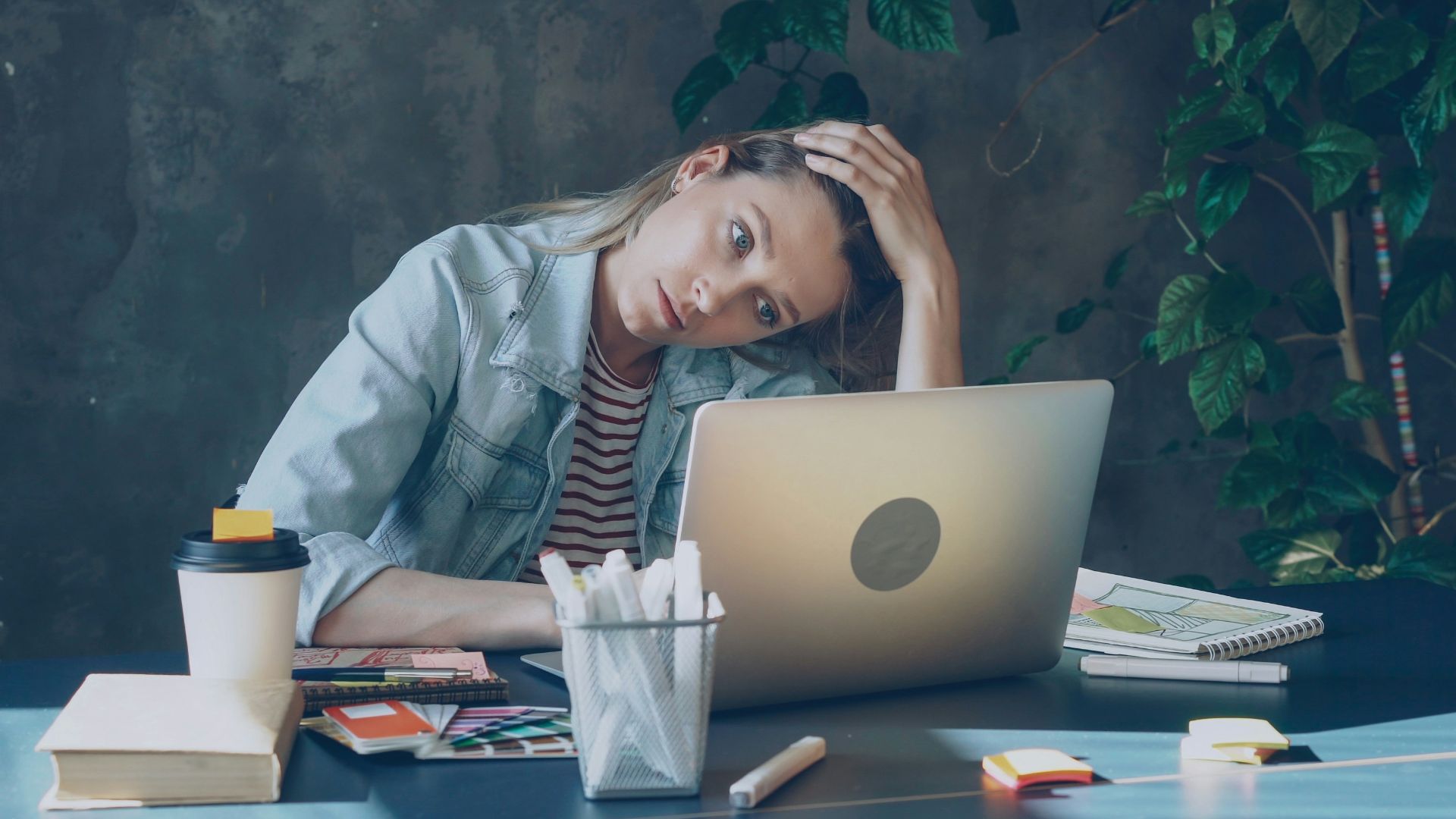 A woman appears stressed while working on laptop.