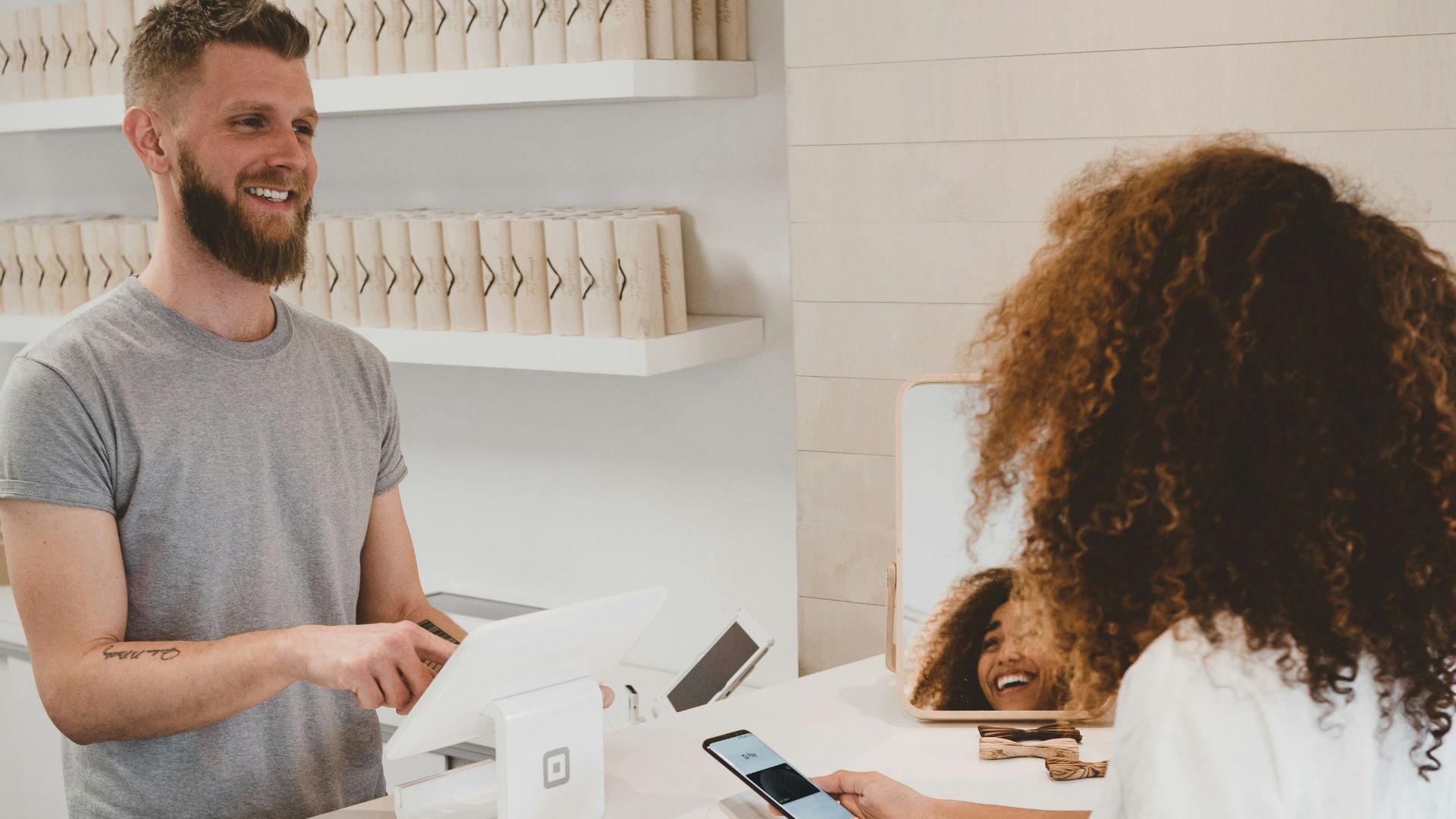 man in grey crew-neck t-shirt smiling to woman on counter