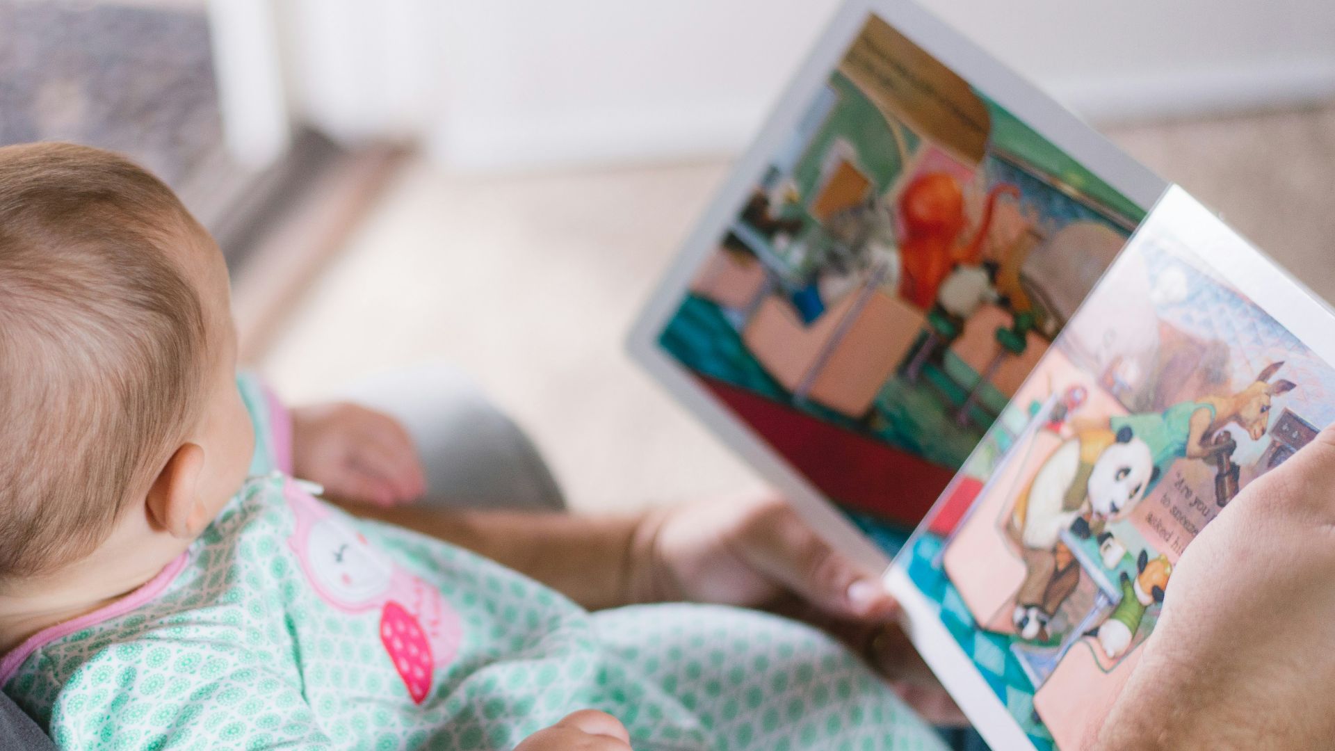 person carrying baby while reading book
