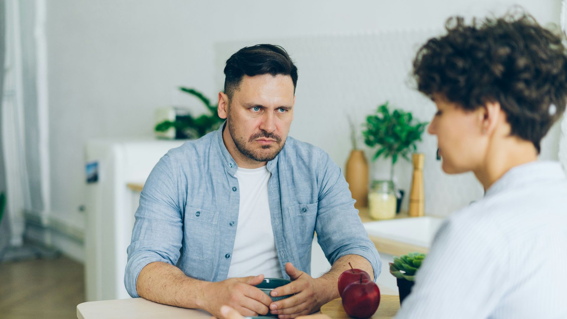 a man sitting at a table talking to a woman