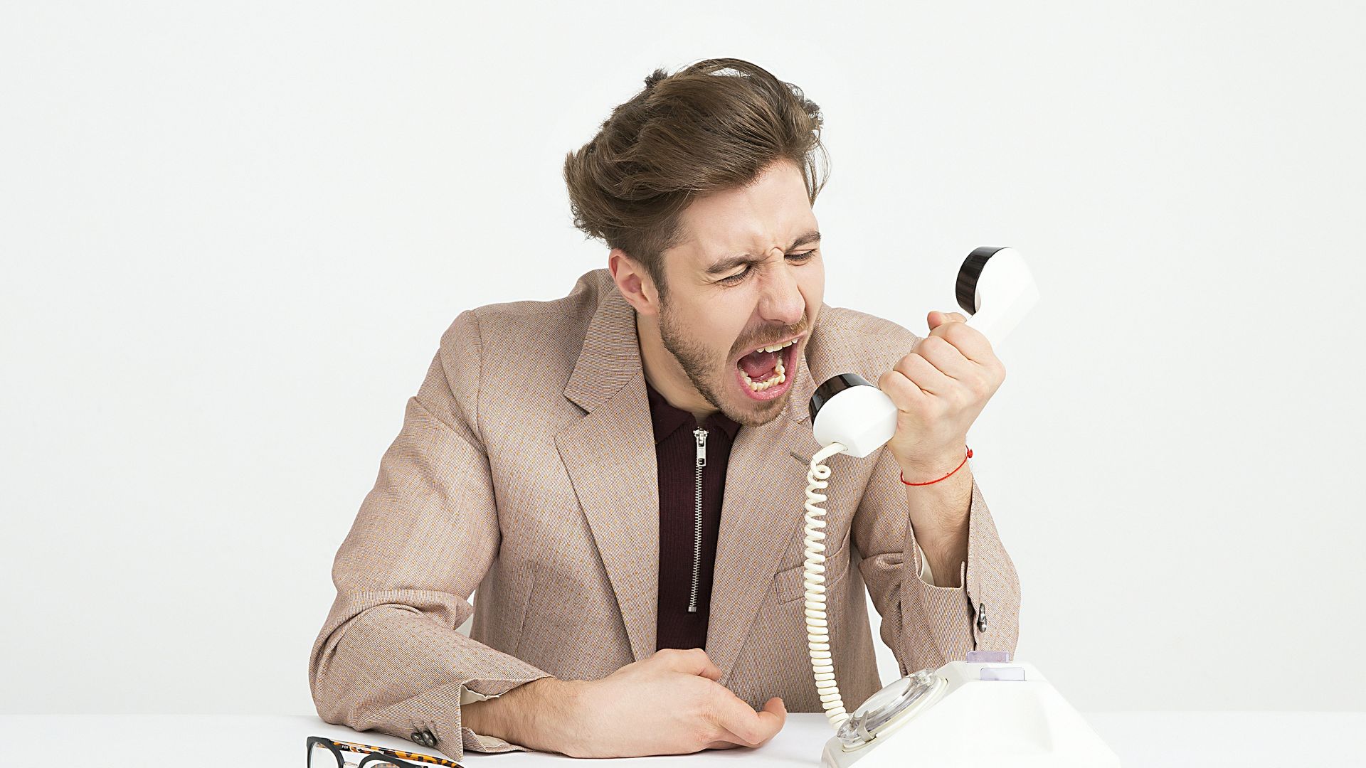 man holding telephone screaming
