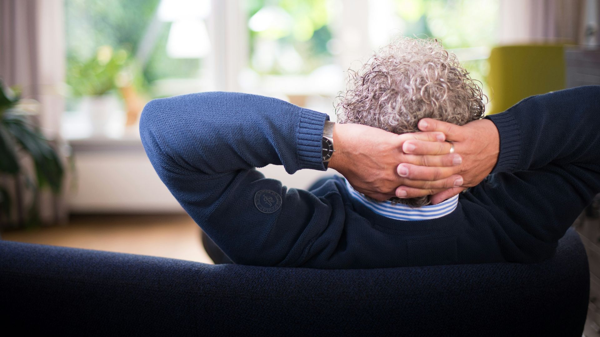 man lying on black couch