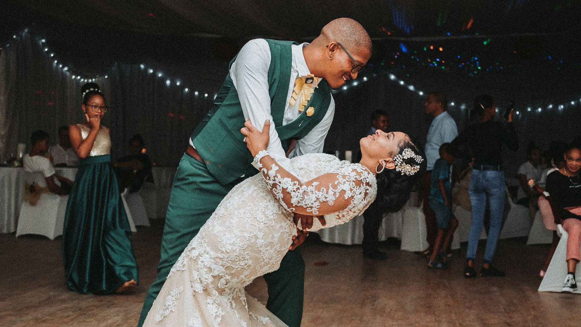 man in black suit jacket holding woman in white wedding dress