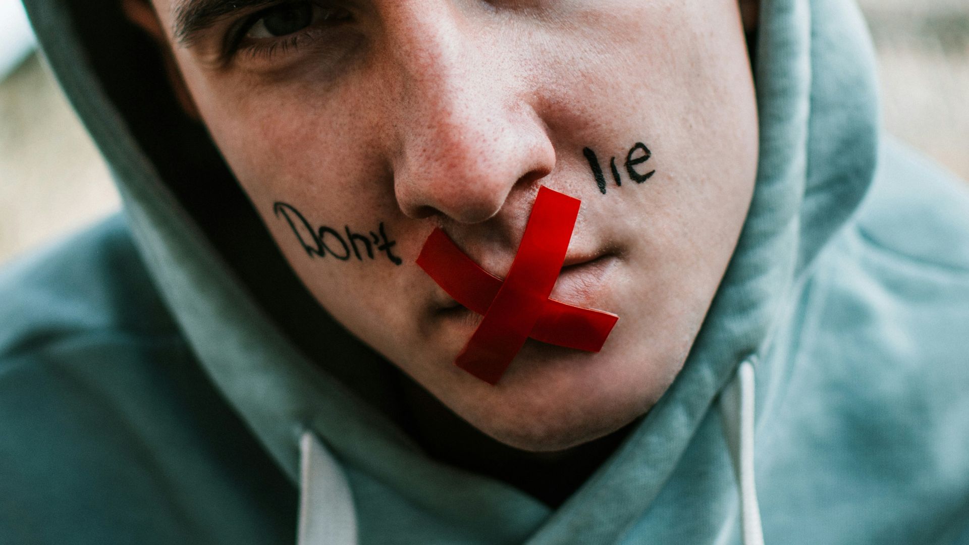man in gray hoodie with red heart on his head