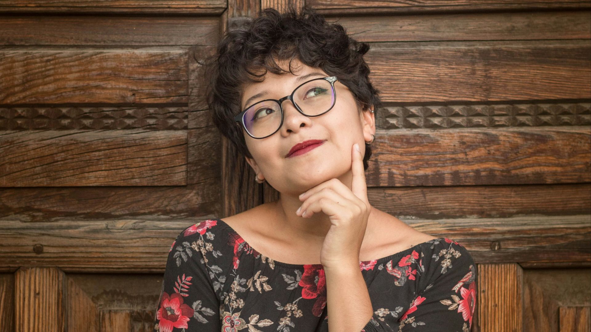 woman leaning against door while holding her cheek