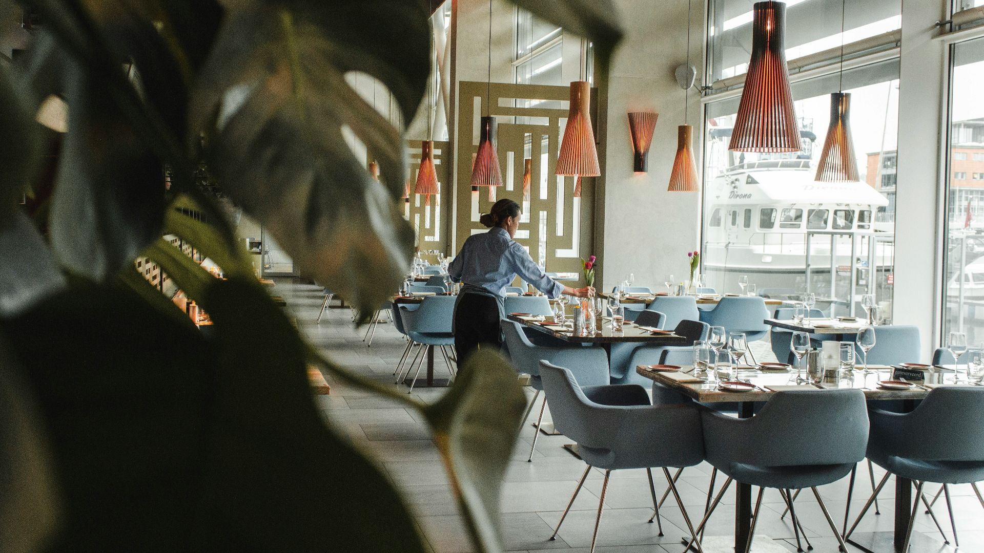 woman in front on brown dining table and chairs inside building