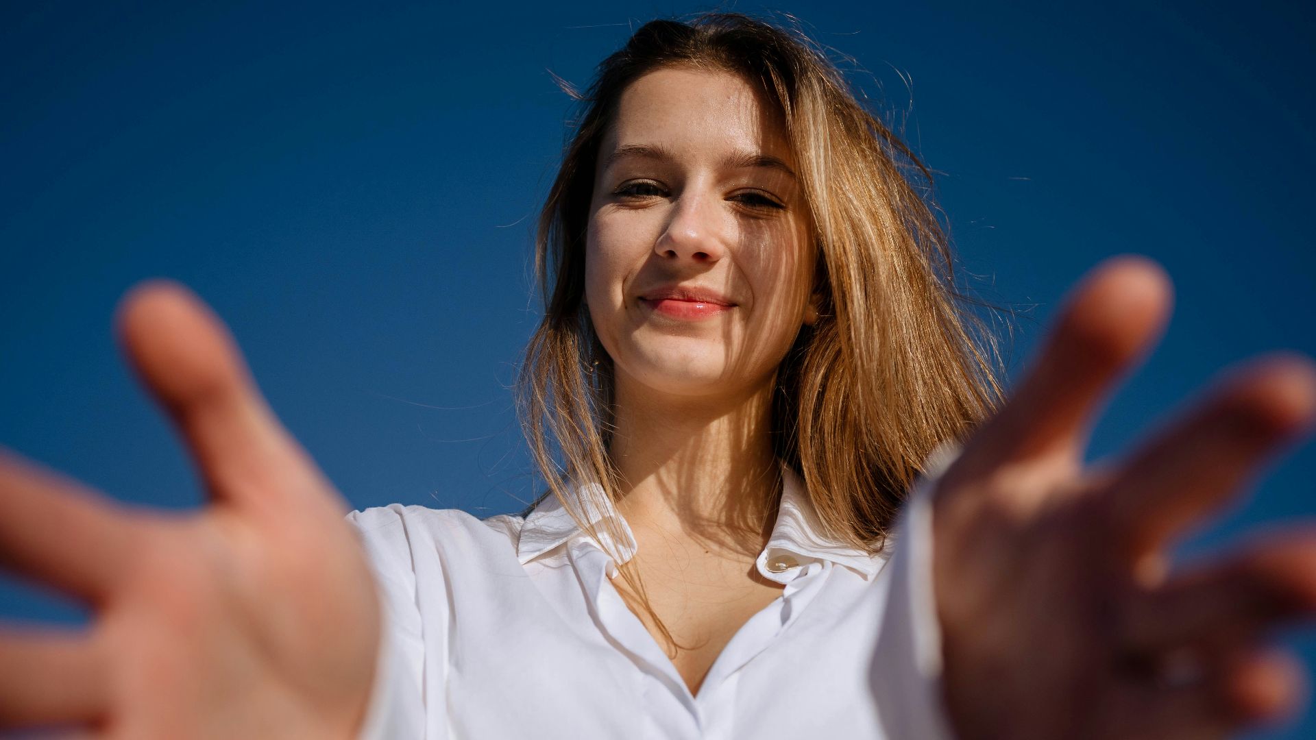 a woman in a white shirt holding out her hands
