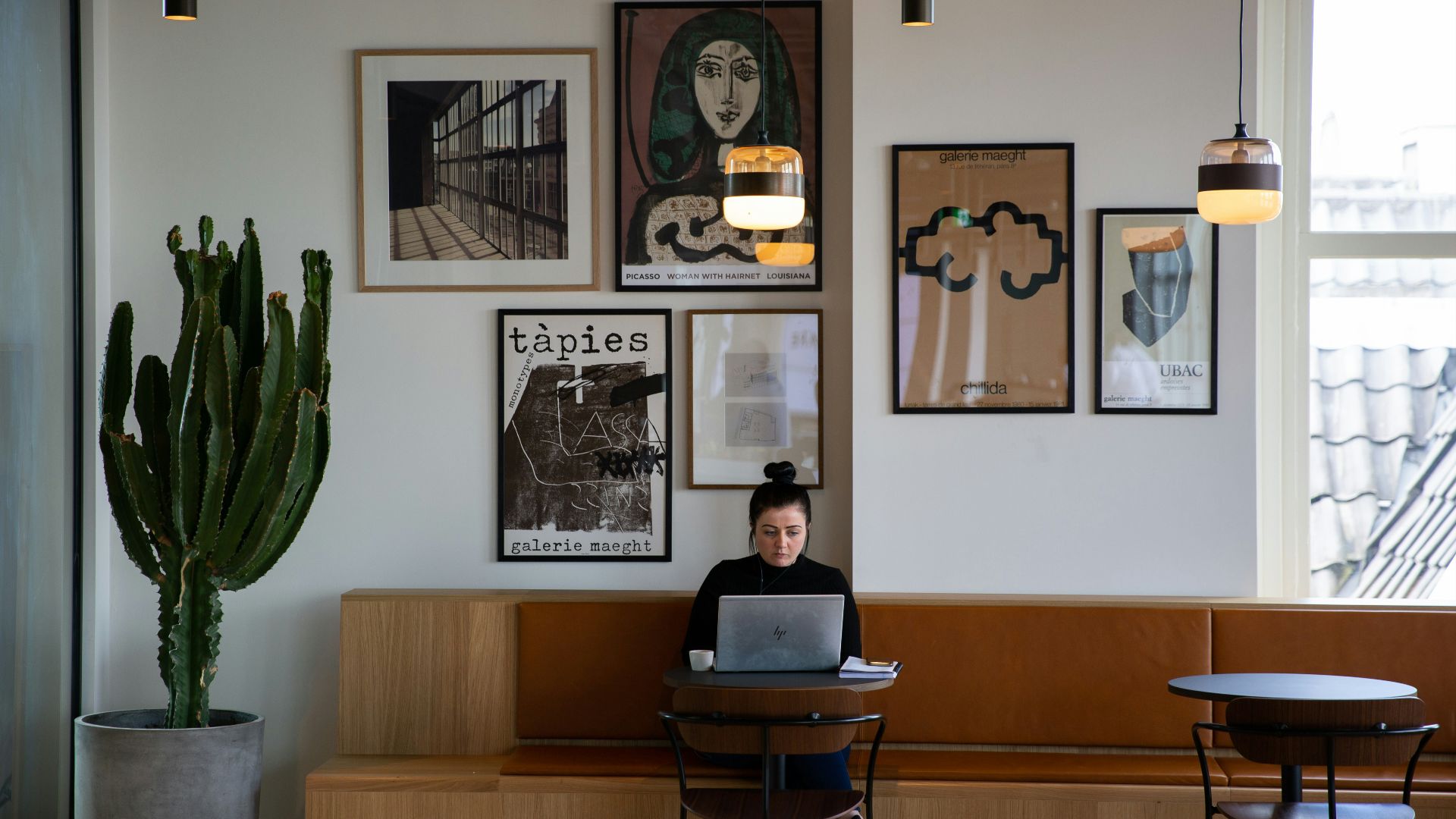 woman in black long sleeve shirt sitting on brown wooden chair