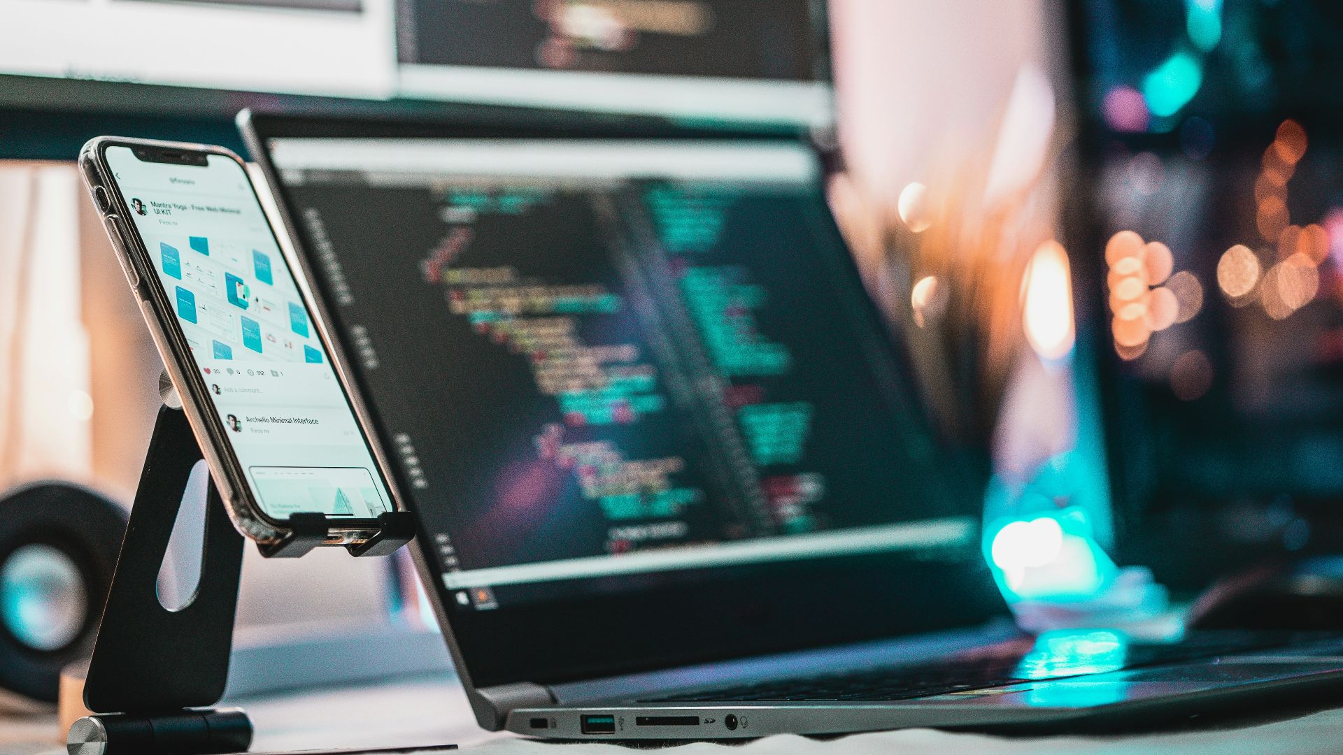 black laptop computer turned on near black and white electronic devices