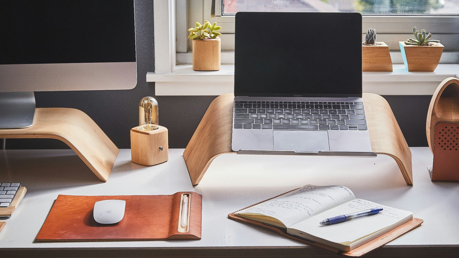 black and silver laptop on brown wooden rack