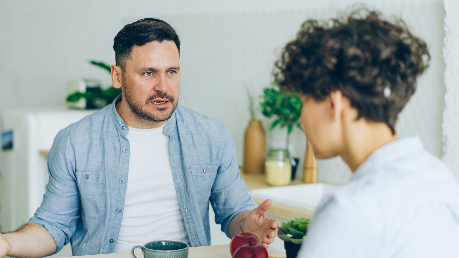 a man sitting at a table talking to a woman