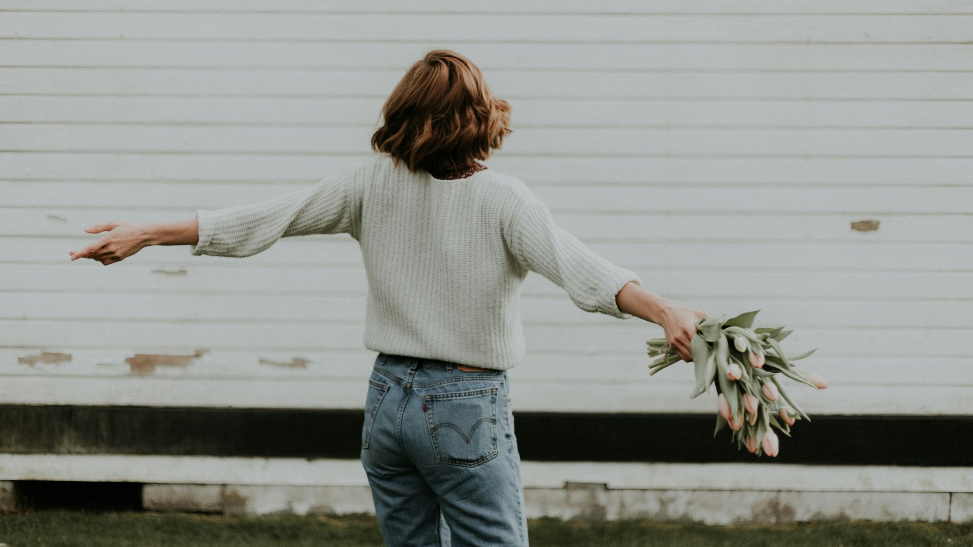 woman holding pink petaled flower