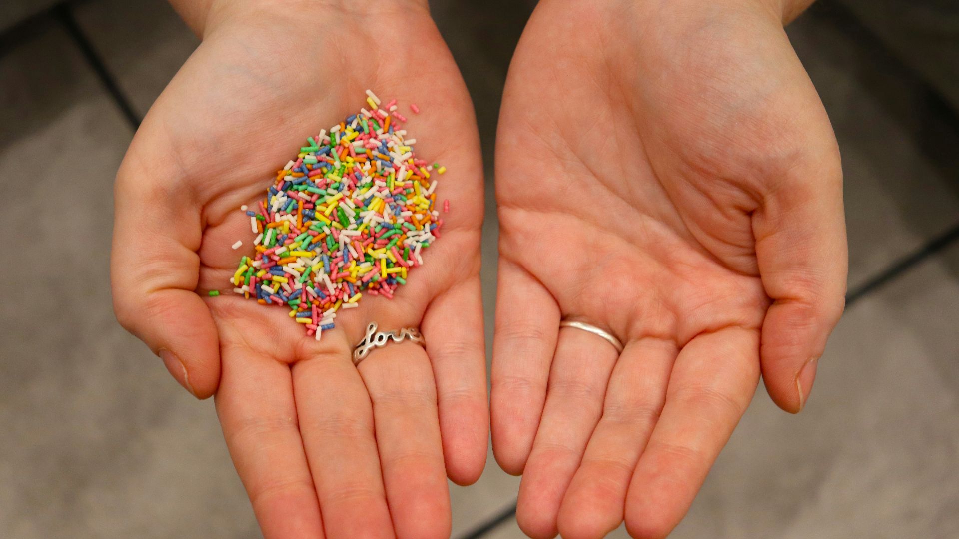 a person holding a handful of sprinkles in their hands