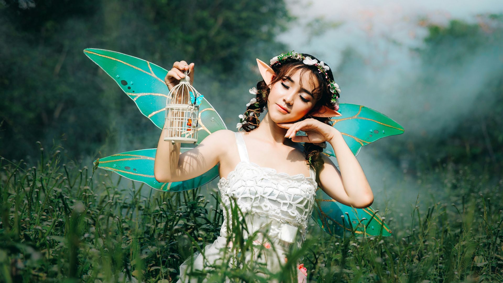 woman in white dress wearing green fairy wings