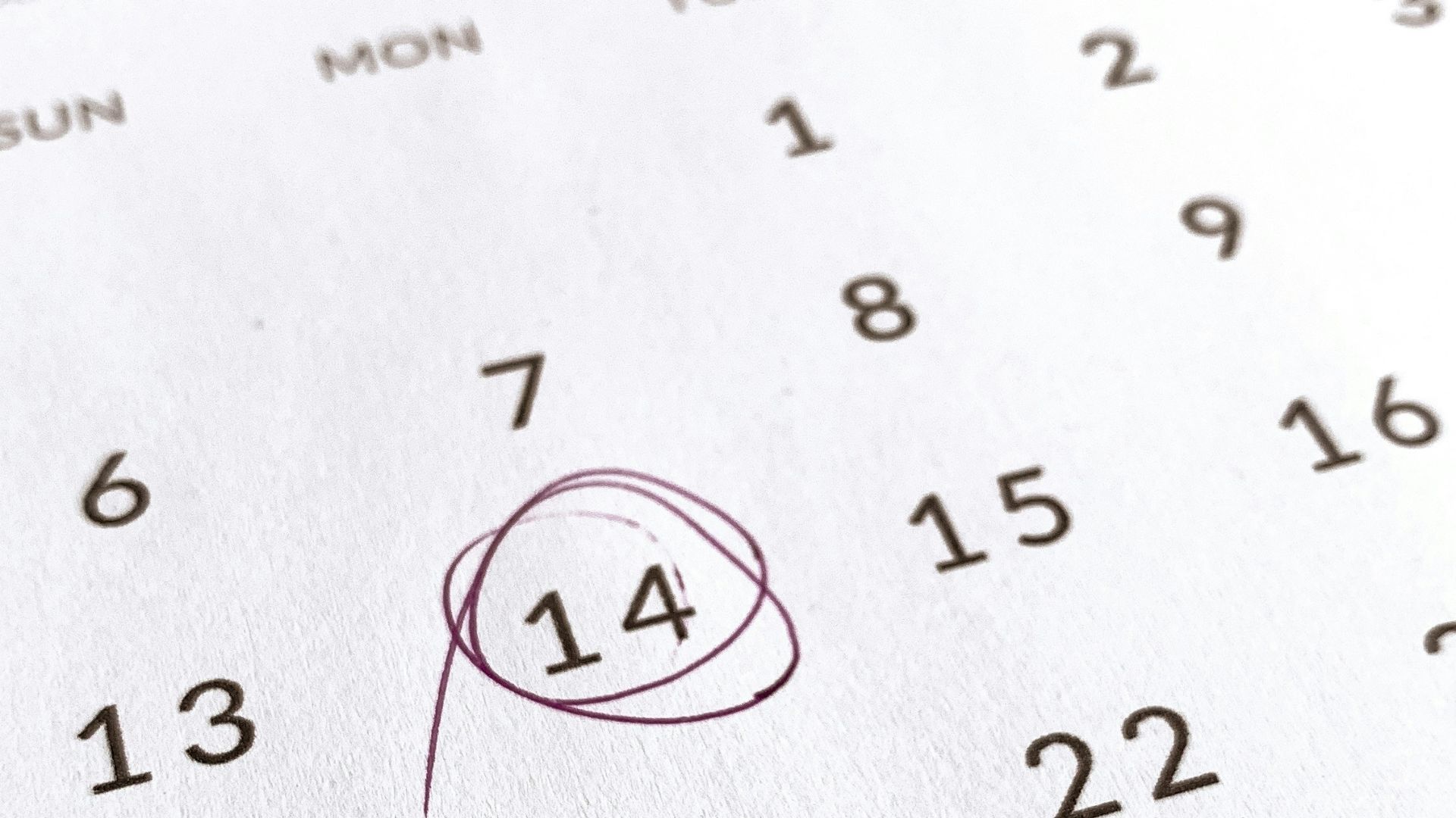 a close up of a calendar with a red marker