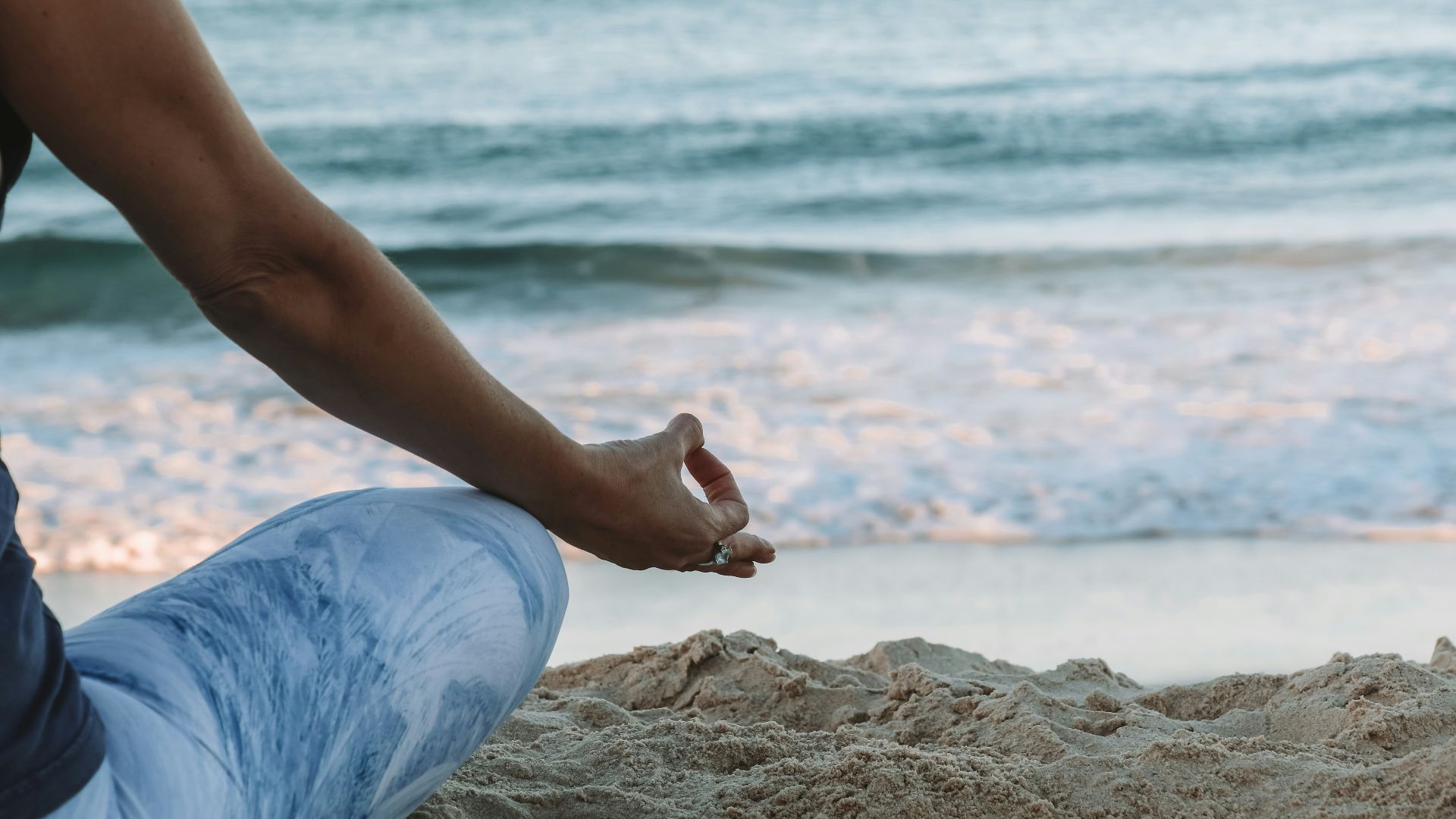 person in blue shorts sitting on beach shore during daytime