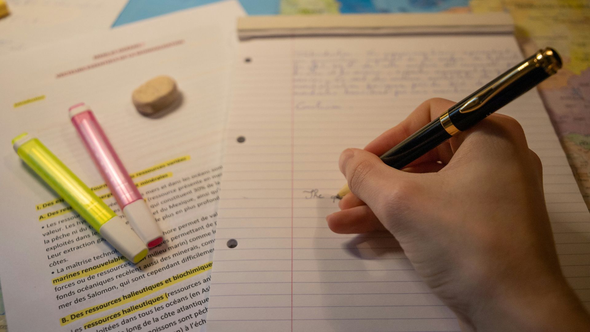 a person writing on a notebook with a pen