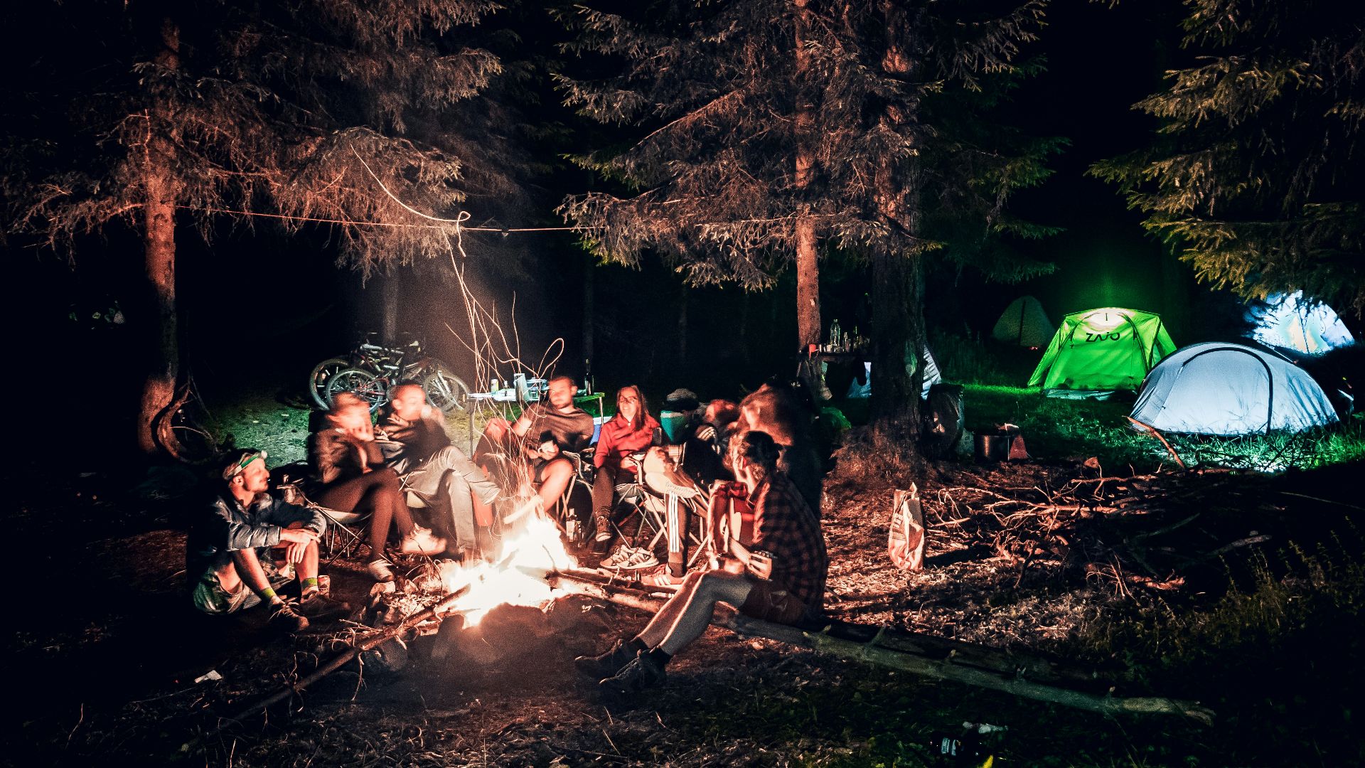 a group of people sitting around a campfire