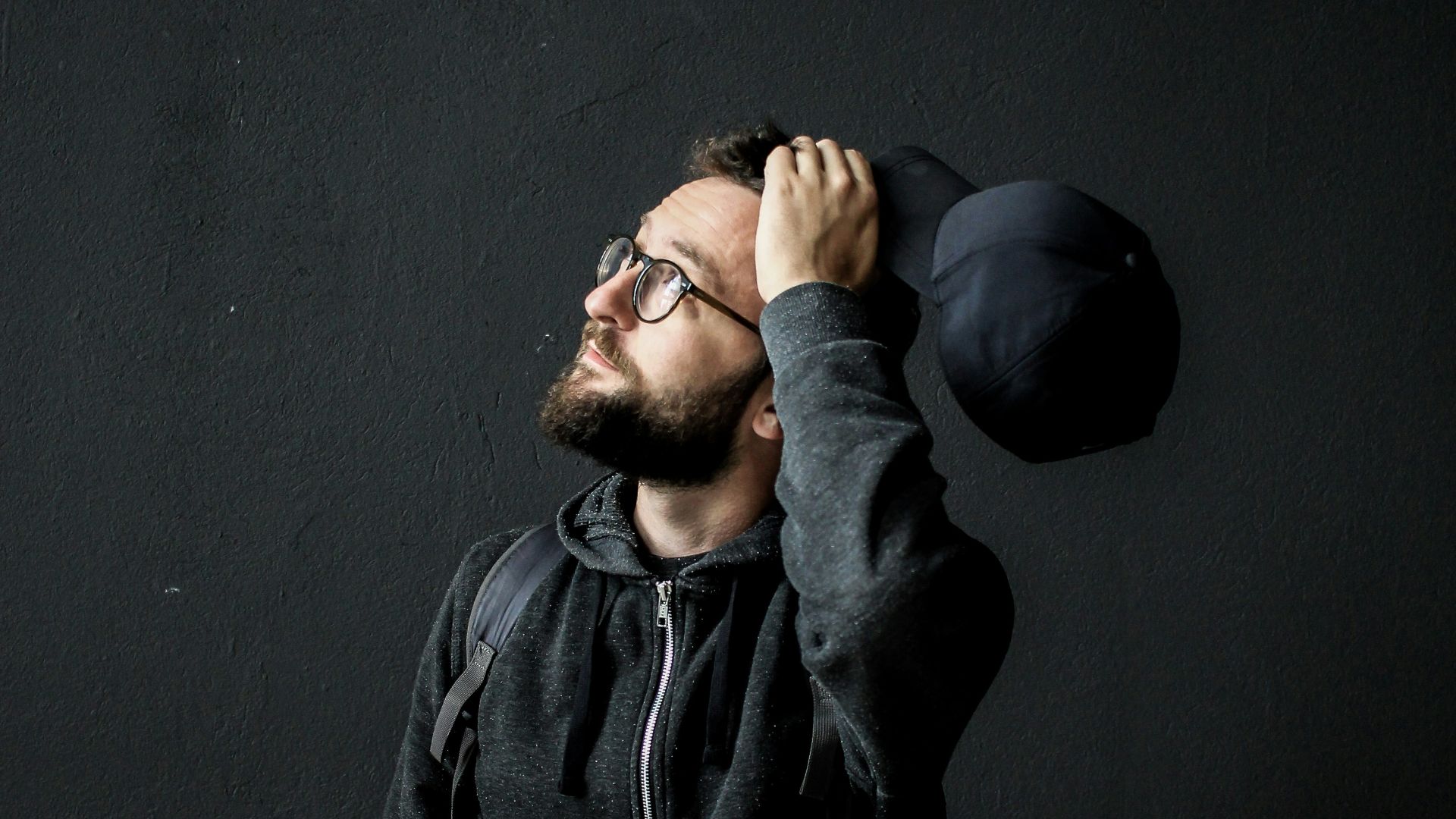 man looking up holding his hair