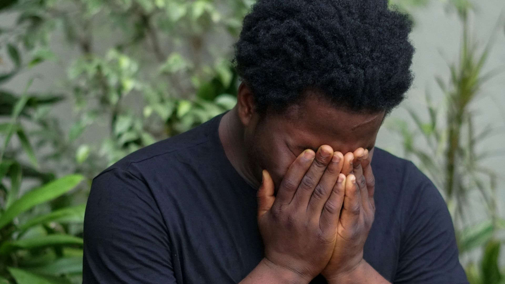 a man covers his face with his hands