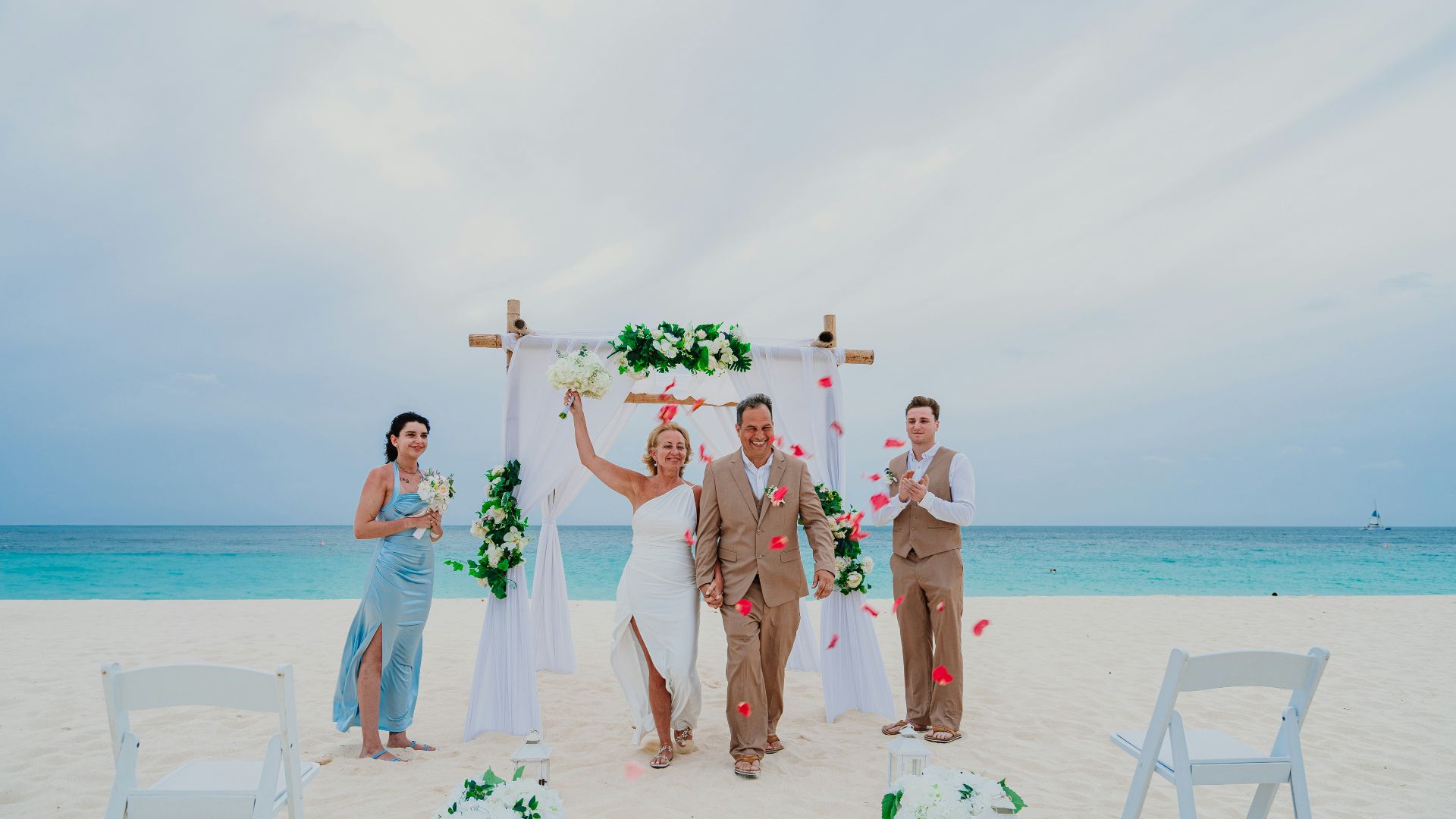 Newlyweds celebrate after their beach wedding ceremony.