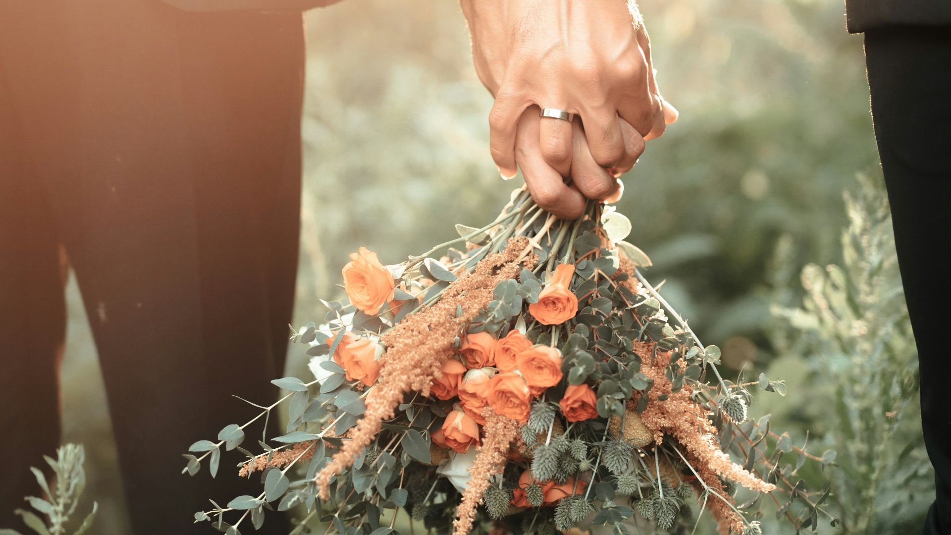 a couple of people holding a bouquet of flowers