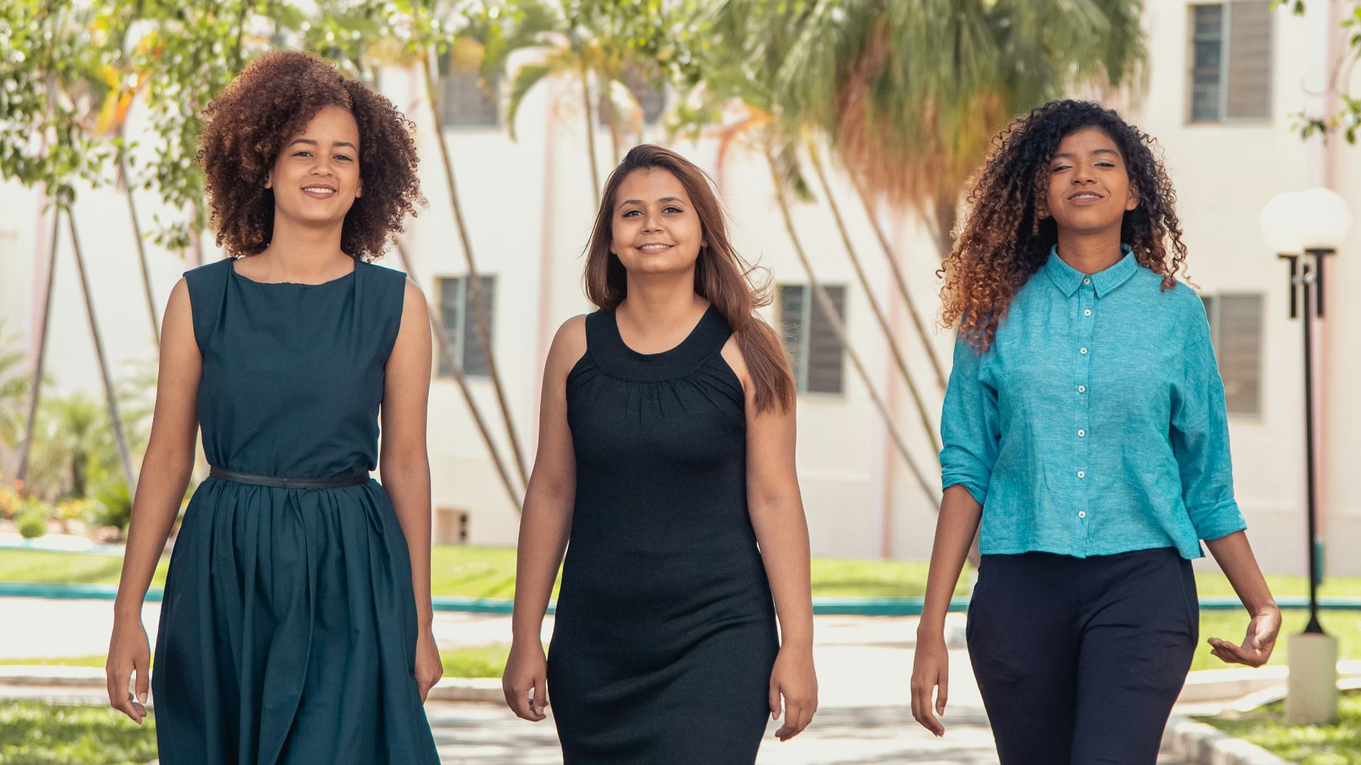 2 women in blue sleeveless dress standing on gray concrete pathway during daytime
