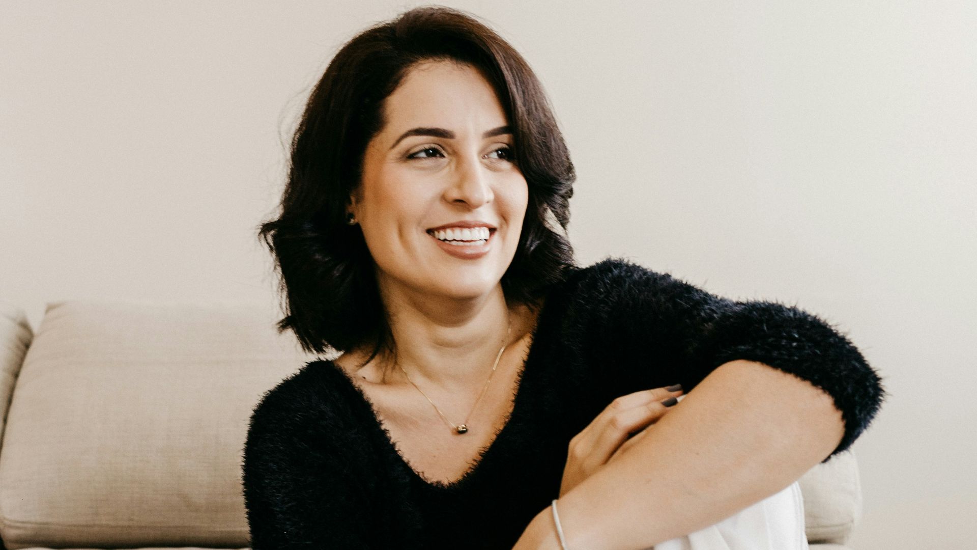 woman in black long sleeve shirt sitting on white couch